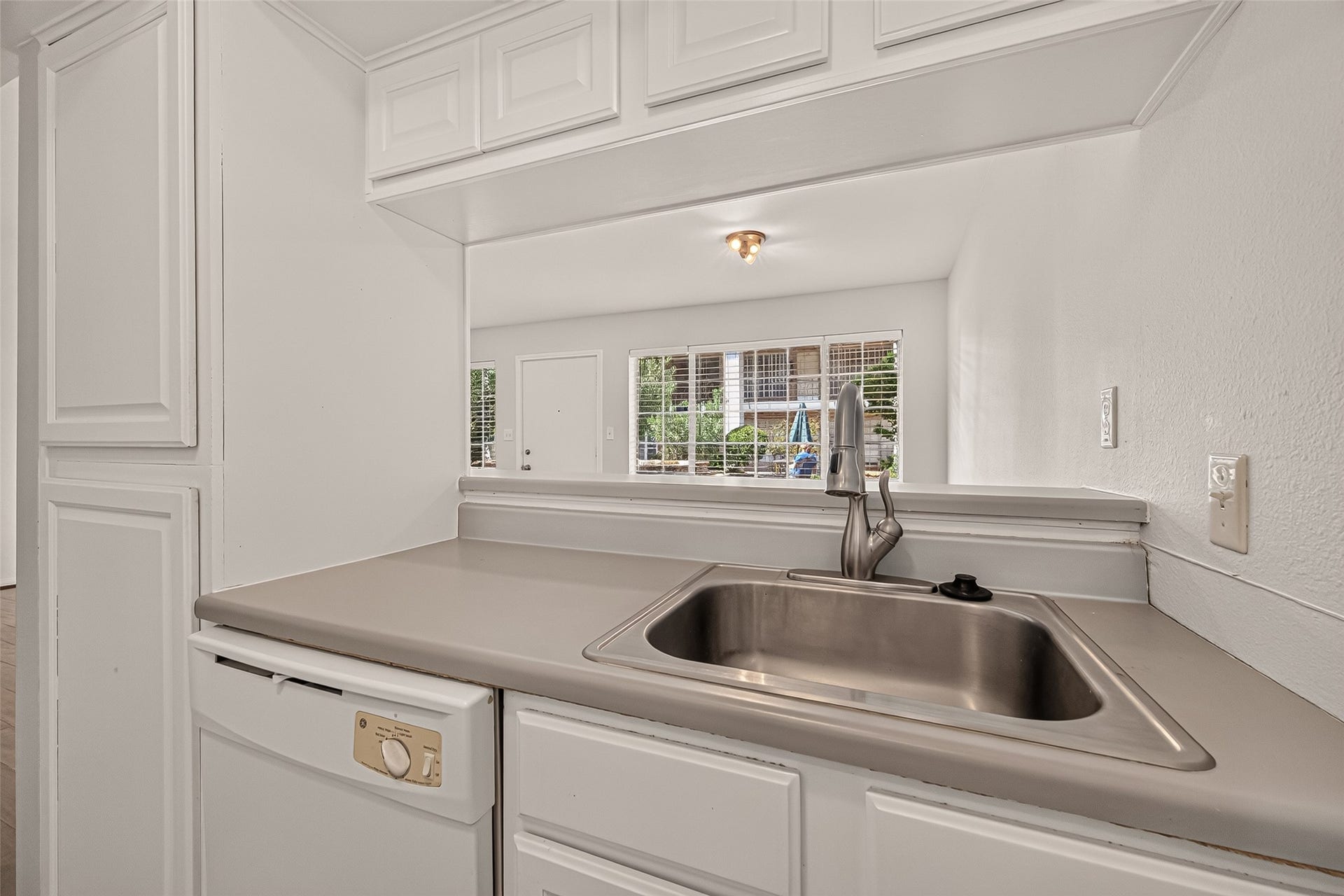 5343 Richmond Avenue, #4, Houston, TX 77056 Bright kitchen with a sleek stainless steel sink and convenient pass-through window to the living area, enhancing the open-concept feel.