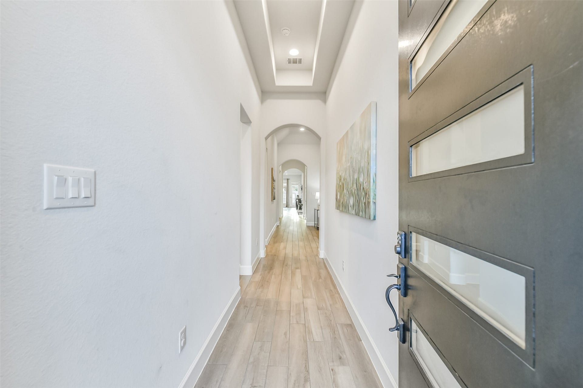 20815 Clydesdale Post Road, Tomball, TX 77377 A wood and glass door opens to a beautiful hallway entry featuring high ceilings and gorgeous arched doorways.