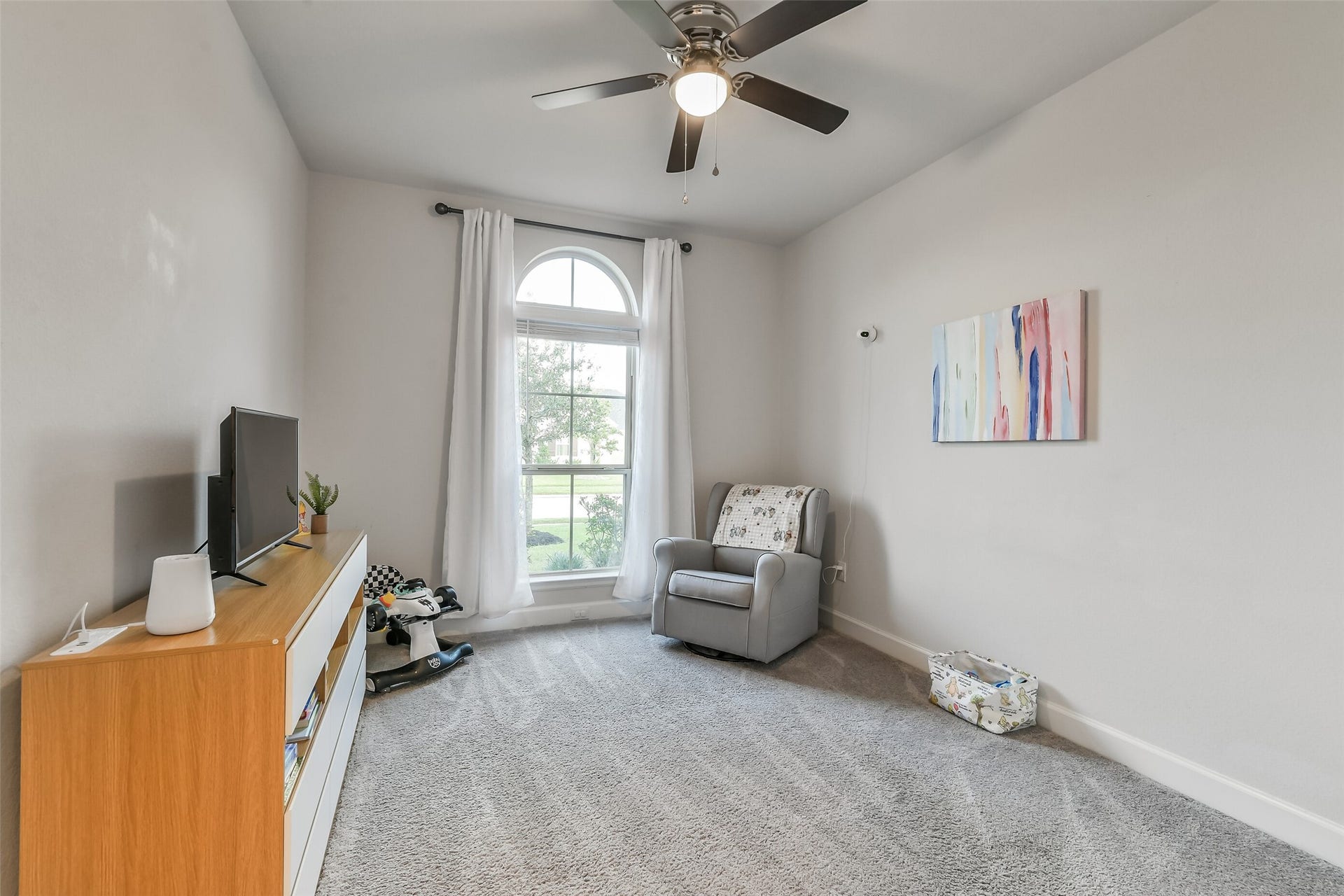 20815 Clydesdale Post Road, Tomball, TX 77377 Secondary bedroom #1 features a beautiful arched window and ceiling fan.