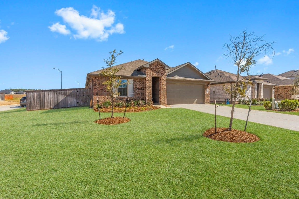 Charming, single-story brick home with a well-maintained lawn and a double-wide driveway leading to a two-car garage.