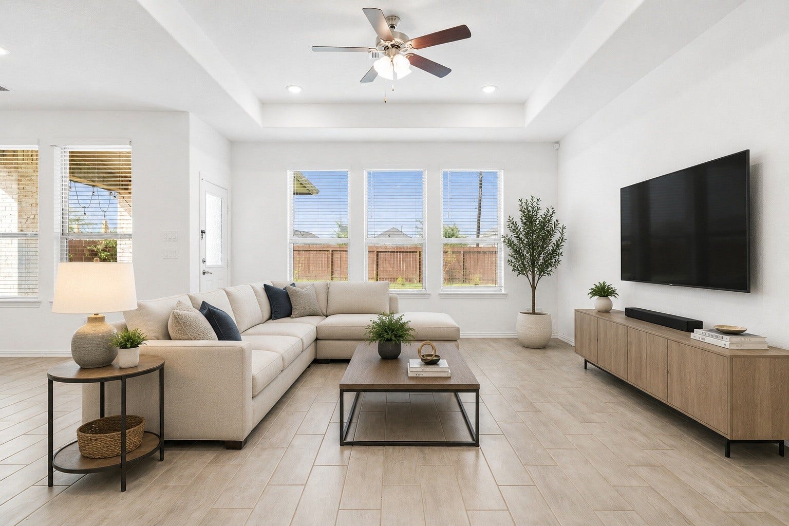 31619 Donoso Drive, Fulshear, TX 77441 The spacious living area features a tray ceiling, ceiling fan and a wall of windows framing backyard views. Virtually staged.
