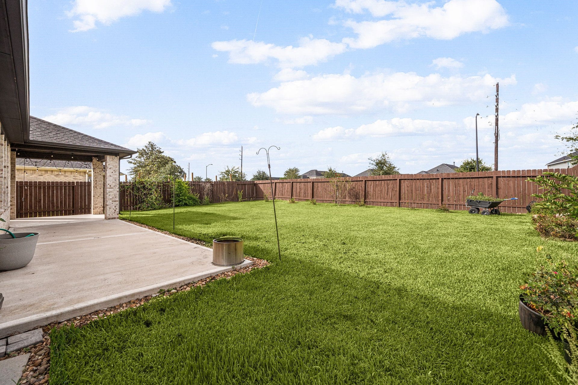 31619 Donoso Drive, Fulshear, TX 77441 The fully fenced backyard offers a spacious lawn beyond the patio, with plenty of room to garden, play, or entertain.