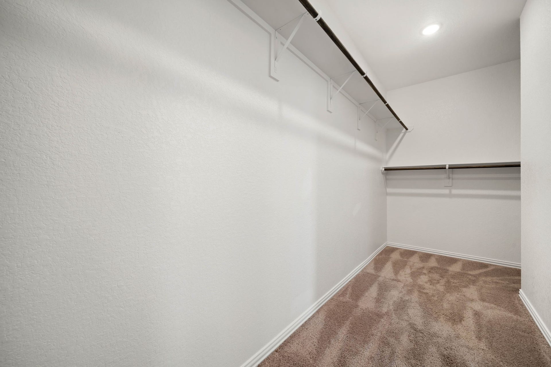 31619 Donoso Drive, Fulshear, TX 77441 The primary suite's walk-in closet offers generous hanging space and plush carpet for a well-organized wardrobe.