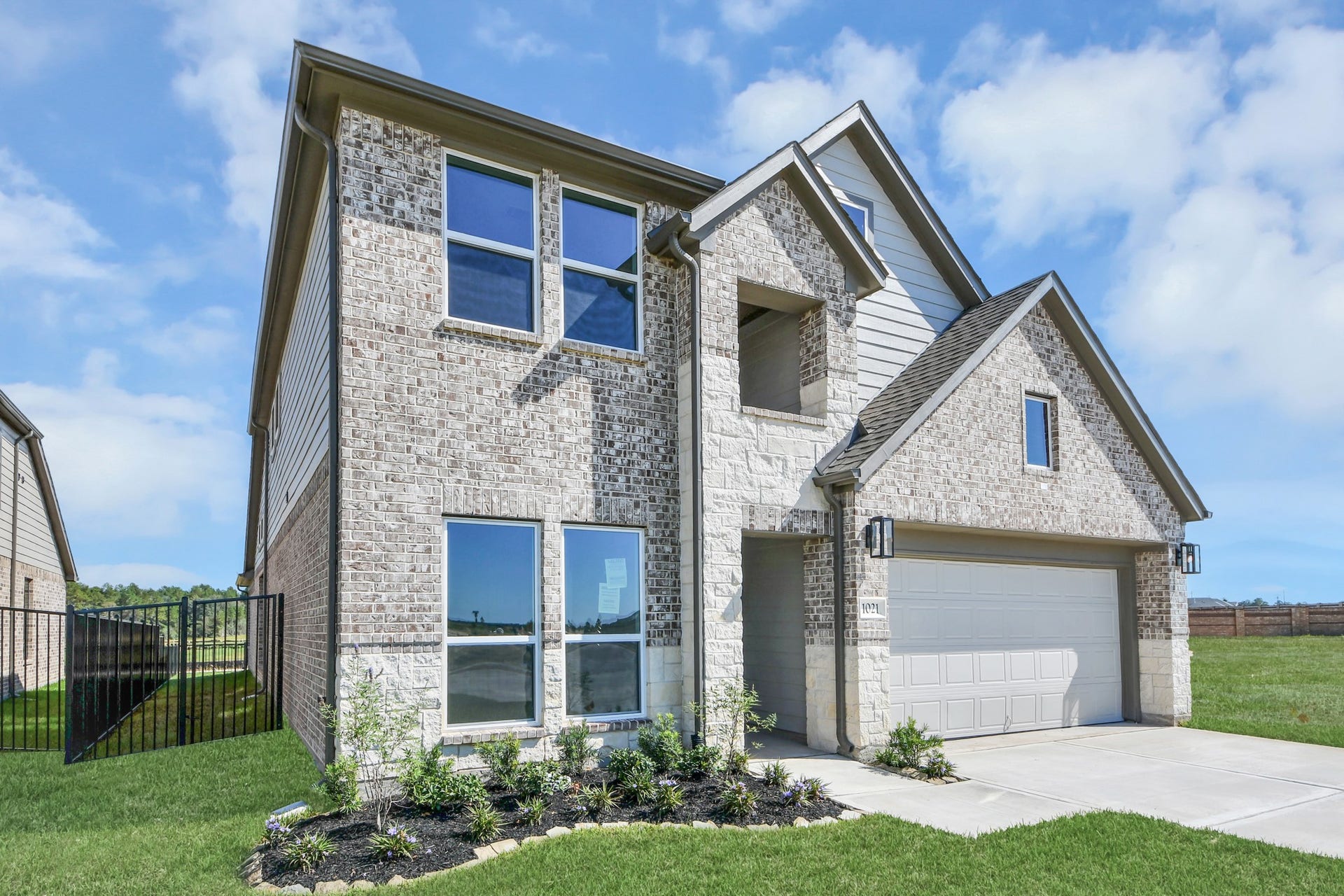 1021 Golden Glow Path, Magnolia, TX 77355 The residence features a practical 2-car garage complemented by a generous driveway, ensuring abundant space for parking needs.