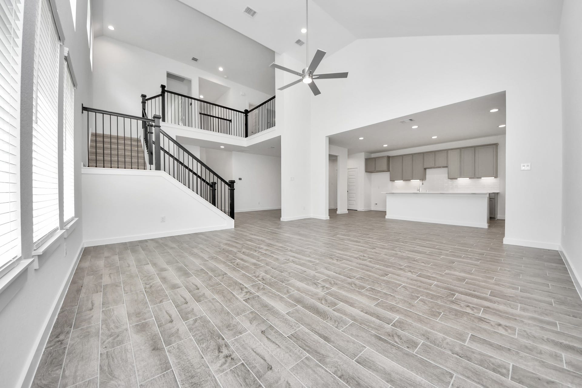 1021 Golden Glow Path, Magnolia, TX 77355 Relax and unwind in this inviting family room, illuminated by abundant natural light streaming in through tall windows, complemented by high ceilings and stunning flooring. Stay comfortable year-round with the gentle breeze from the ceiling fan, creating the perfect atmosphere for family gatherings. Sample photo of completed home with similar floor plan. Actual colors and selections may vary.