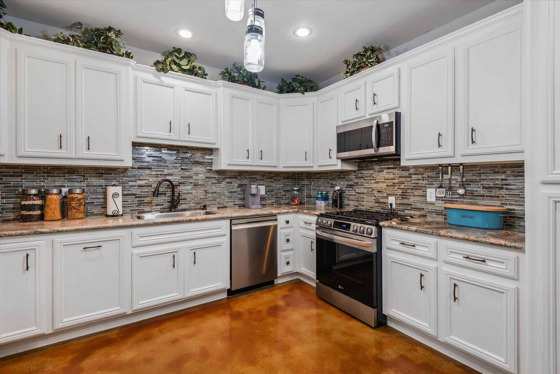 11578 28th Street, Santa Fe, TX 77510 Kitchen with granite countertops, tiled backsplash, stainless-steel appliances, and stained concrete floors.