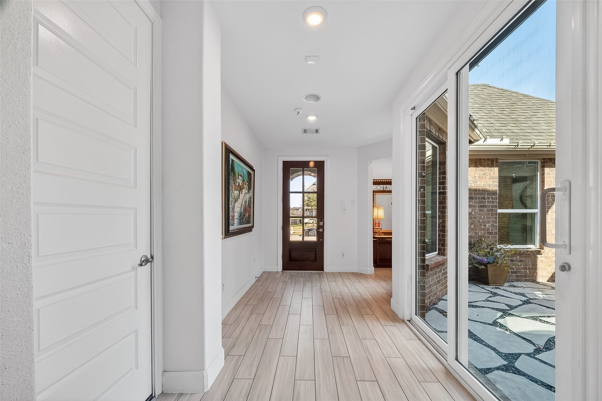 51 Scepter Ridge, Sugar Land, TX 77498 The long gallery hallway offers a bright transition into the main living areas. Recessed lighting and open connections to multiple rooms make this space feel both functional and welcoming.