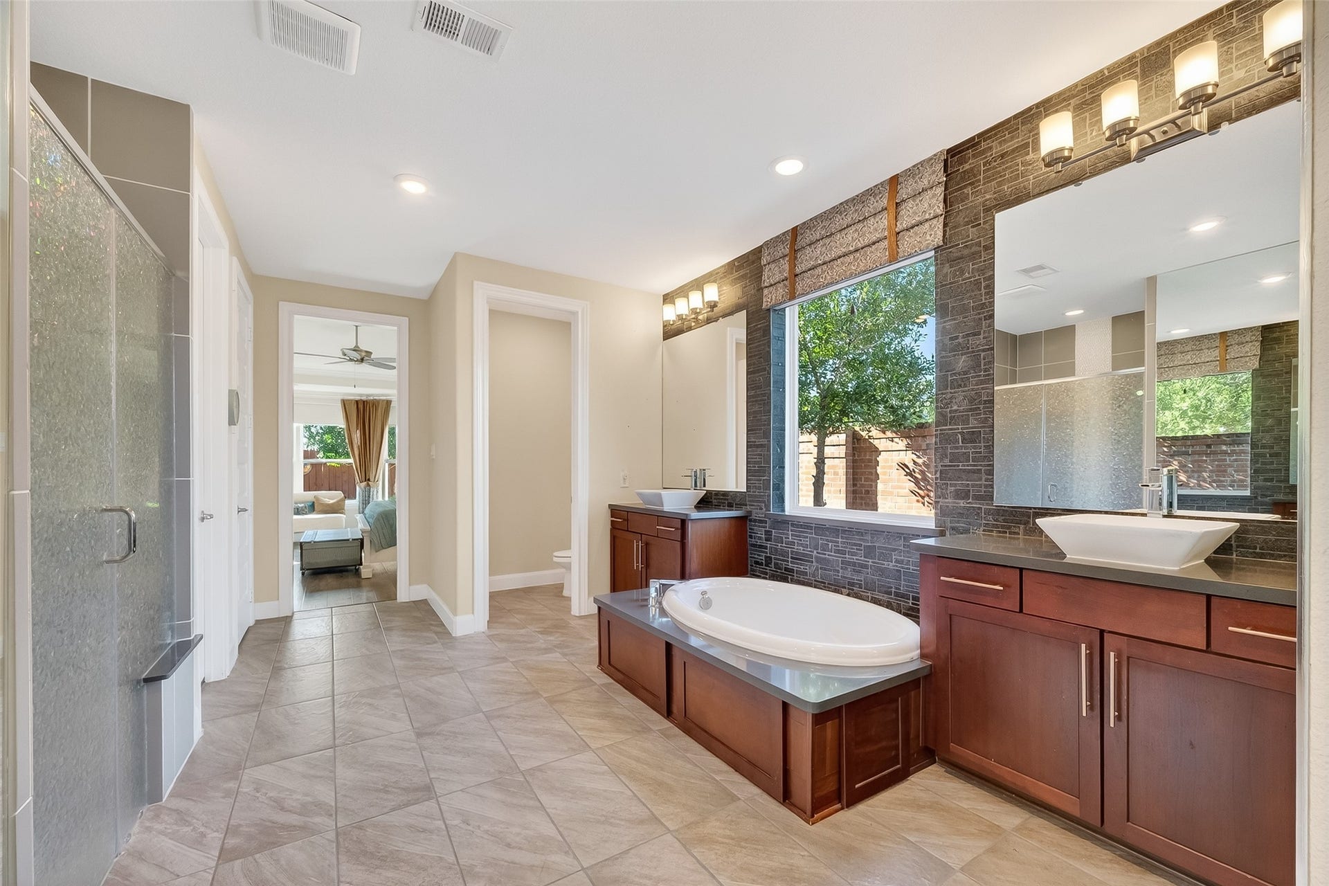 51 Scepter Ridge, Sugar Land, TX 77498 This view of the Primary Bath shows the large walk in shower across from the deep soaking tub. This spa inspired bath has every amenity anyone could possibly want. Note the private water closet at the end of the bathroom.