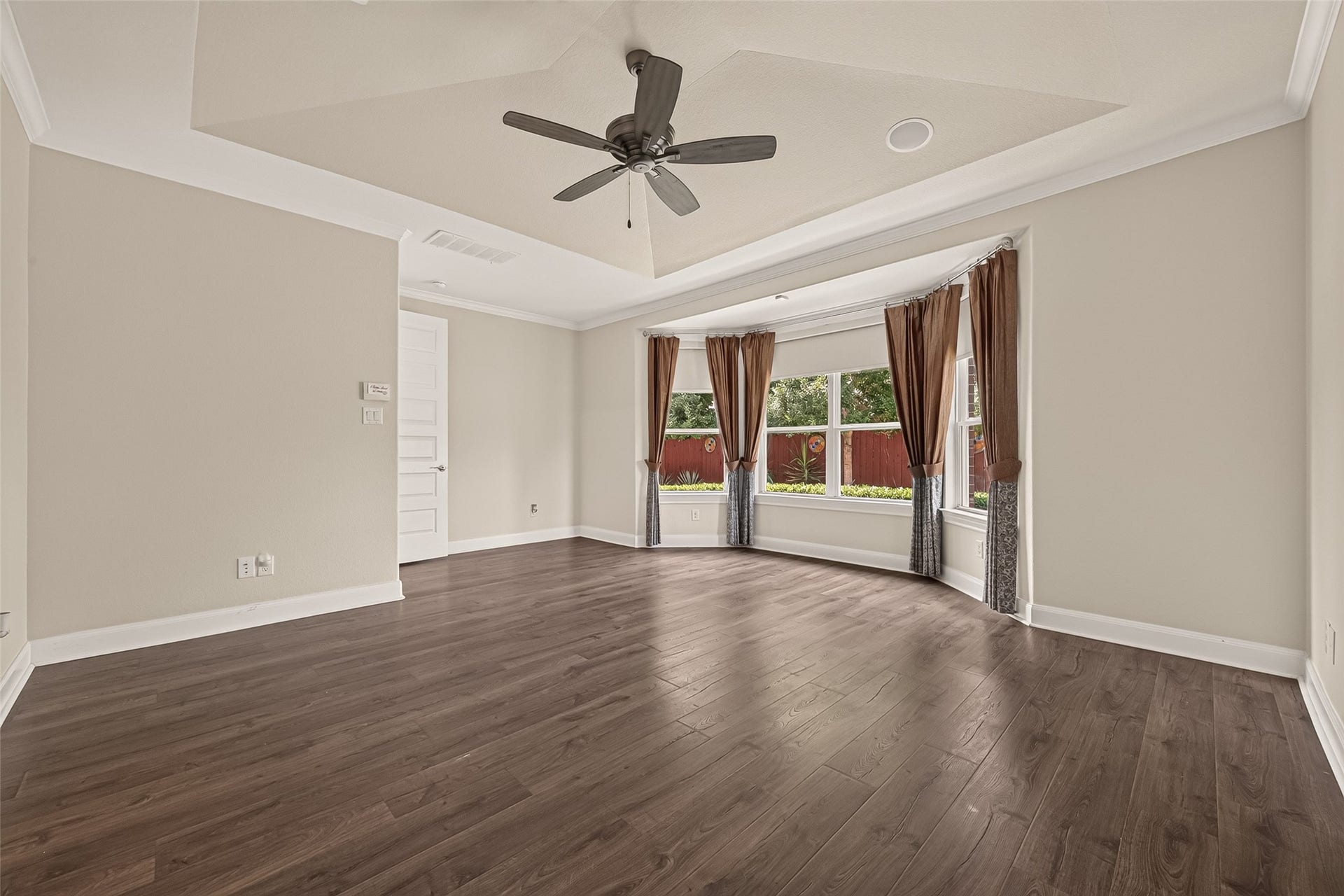 51 Scepter Ridge, Sugar Land, TX 77498 A view of the 1st floor Primary Bedroom toward the Primary Bath. Luxury vinyl flooring, crown molding and a gambrel ceiling add style and sophistication to the suite.