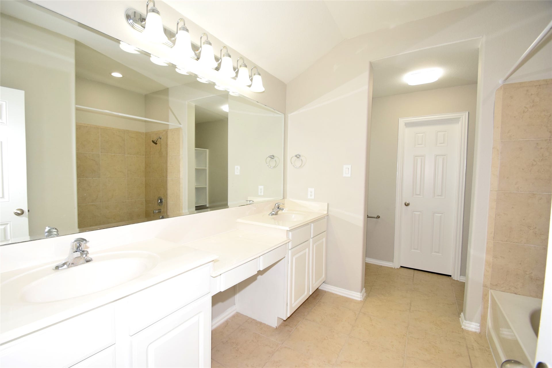 Primary bath offering tile floors, double sinks, vanity area and a garden tub/shower.