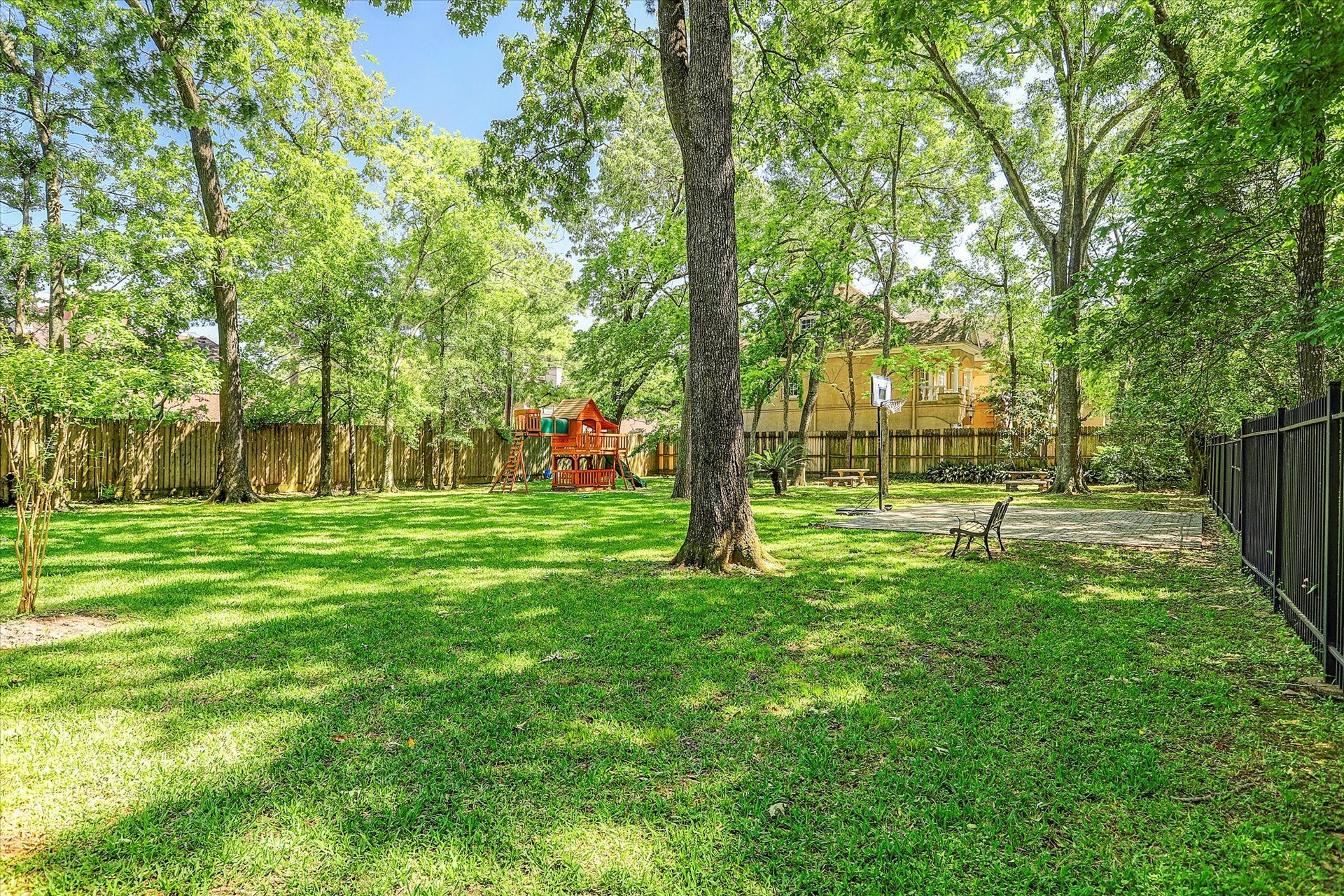 Great green space and playground with basketball hoop.