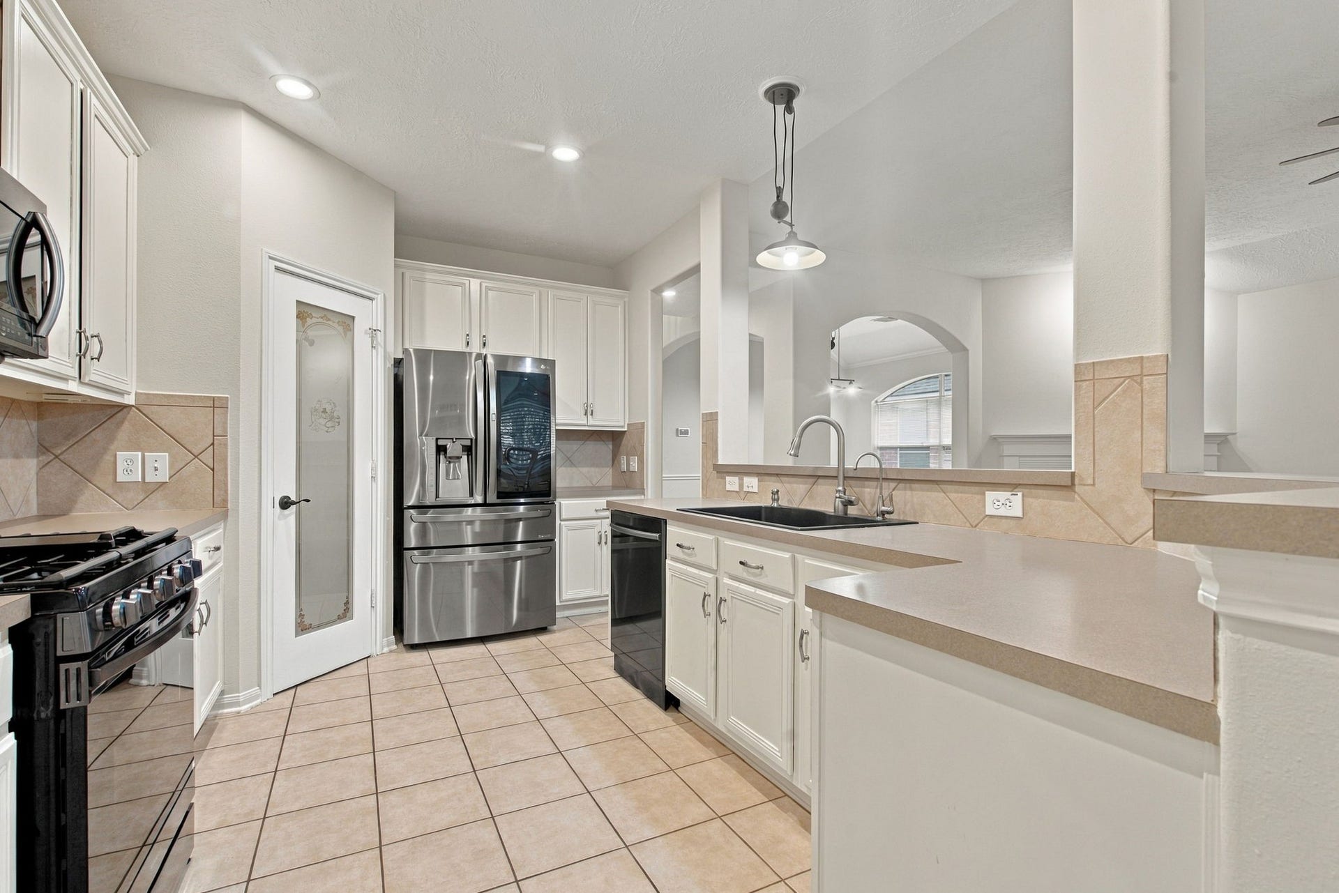 12843 Sherlock Acres Drive, Tomball, TX 77377 Amazing kitchen offers a stone kitchen sink, ample breakfast bar seating, and a walk-in pantry!