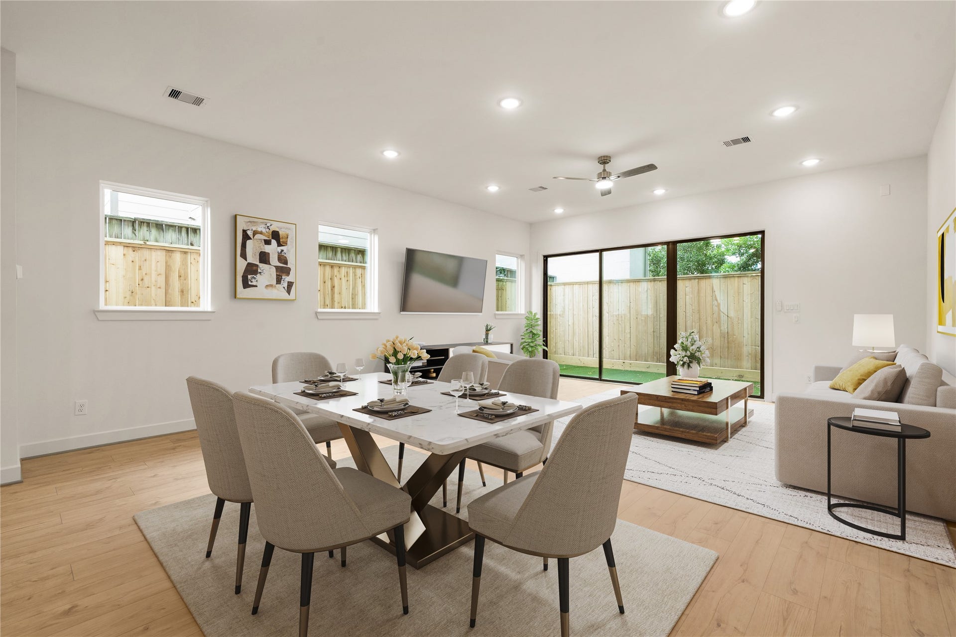 5018 Schuler Street, Houston, TX 77007 Open-concept living and dining marble-topped dining table setup, plush sofa seating area, wall-to-wall light wood floors, and oversized sliding glass doors opening to the private yard.