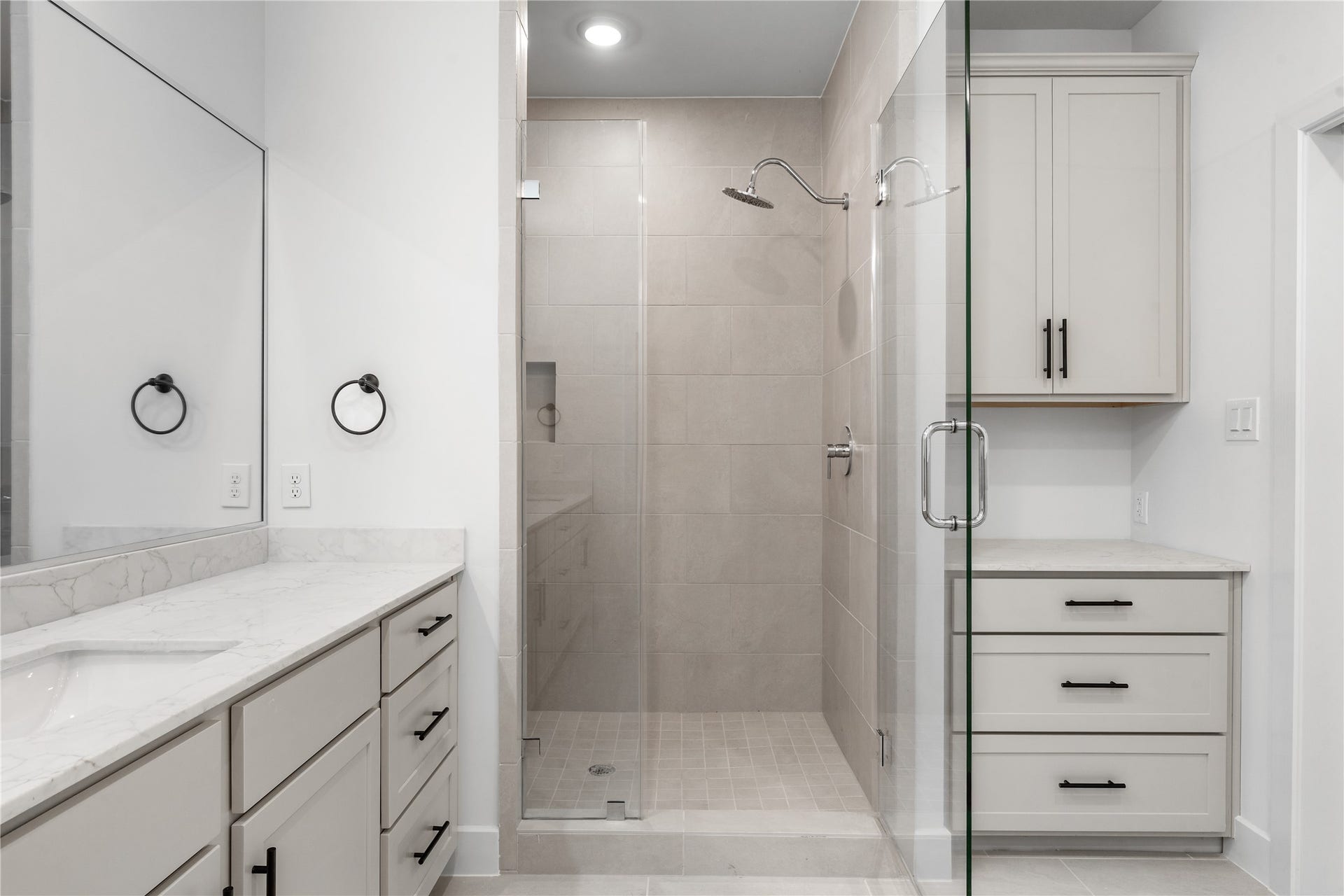 5018 Schuler Street, Houston, TX 77007 Custom primary shower & vanity large-format tile surround, rain showerhead, grey shaker vanity with quartz counter, and built-in linen storage tower.
