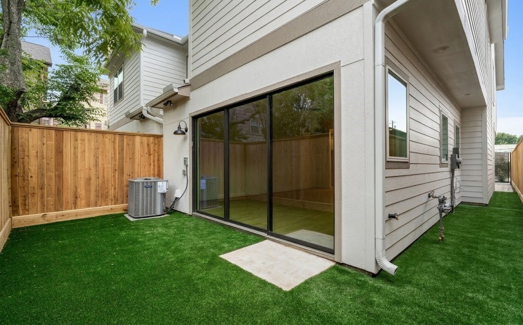5018 Schuler Street, Houston, TX 77007 Private backyard low-maintenance artificial turf, privacy fencing, direct glass sliding door access, and covered exterior entry.