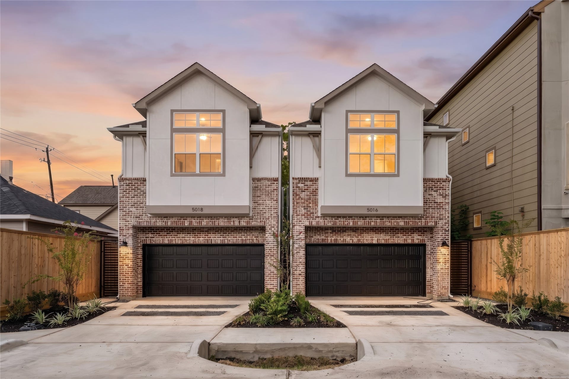 5018 Schuler Street, Houston, TX 77007 Stunning sunset elevation classic brick lower facade paired with clean board-and-batten upper gables, dark garage doors, and manicured entryway landscaping.