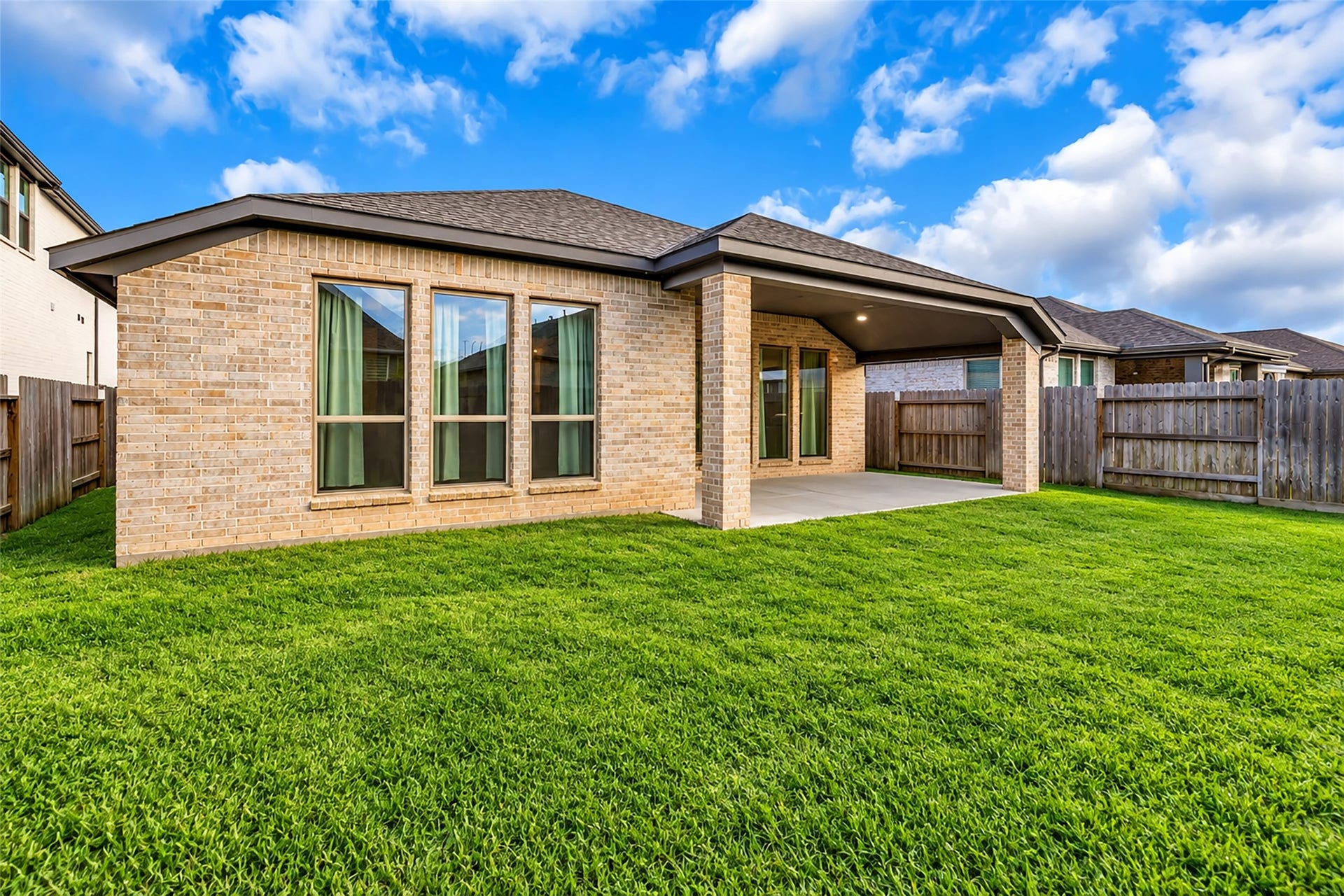 30047 Gold Finch Place, Fulshear, TX 77441 Charming backyard with a spacious covered patio, perfect for outdoor entertaining, surrounded by a well-maintained lawn and privacy fence.