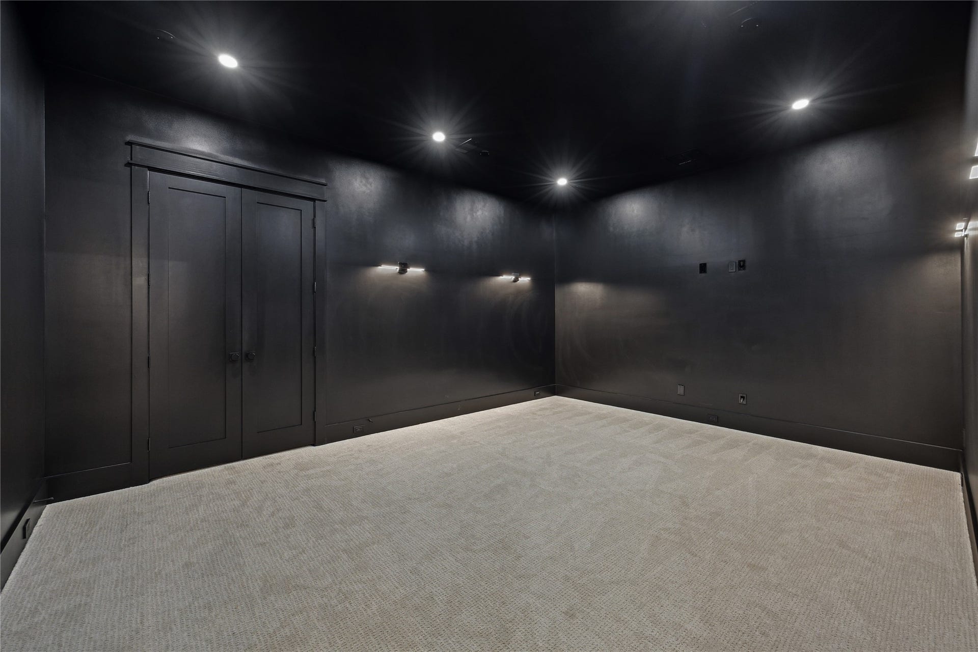 431 W 30th Street, Houston, TX 77018 This is a sleek, modern room with black walls and ceiling, featuring recessed lighting and neutral carpet. It's an ideal space for a home theater or media room.