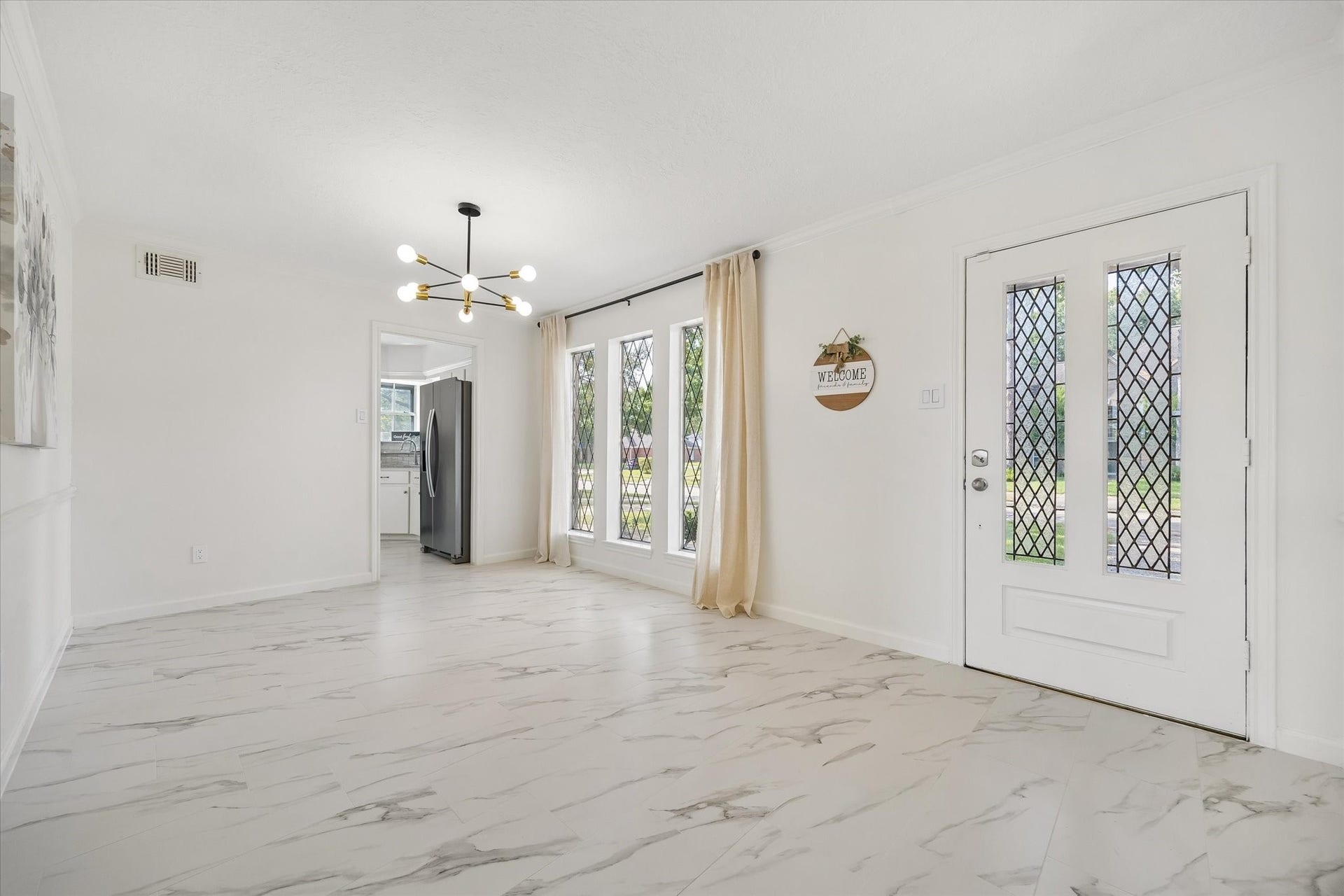 110 Shadow Wood Drive, Sugar Land, TX 77498 Right after the front door is this bright , inviting dining room with large windows, new porcelain flooring, and a contemporary style chandelier.