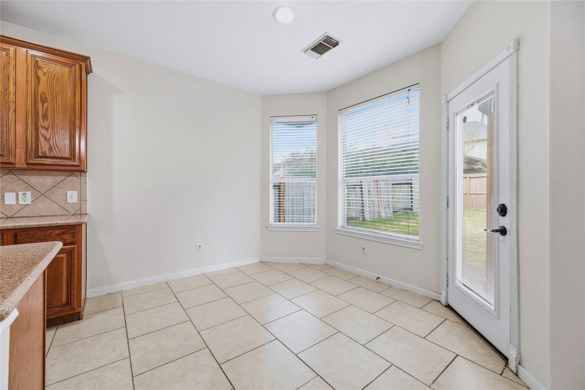 Rear-facing windows brighten the breakfast area, and the adjacent door makes it easy to step outside from the kitchen for an outdoor break.