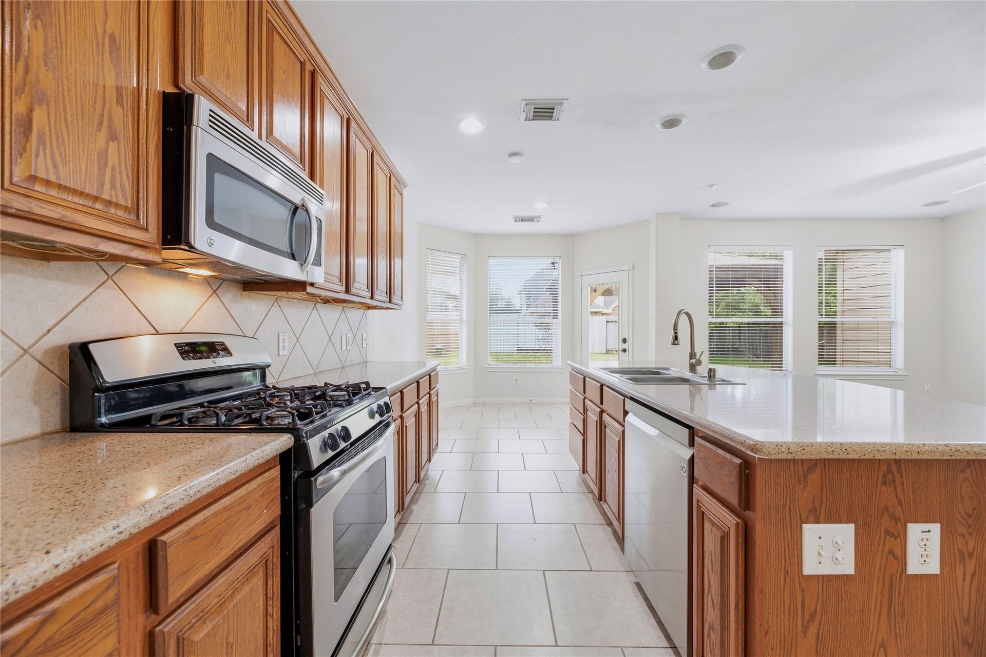 Cabinets along the cooking wall and a central island provide separate places for meal preparation and storage, with the breakfast area just beyond.