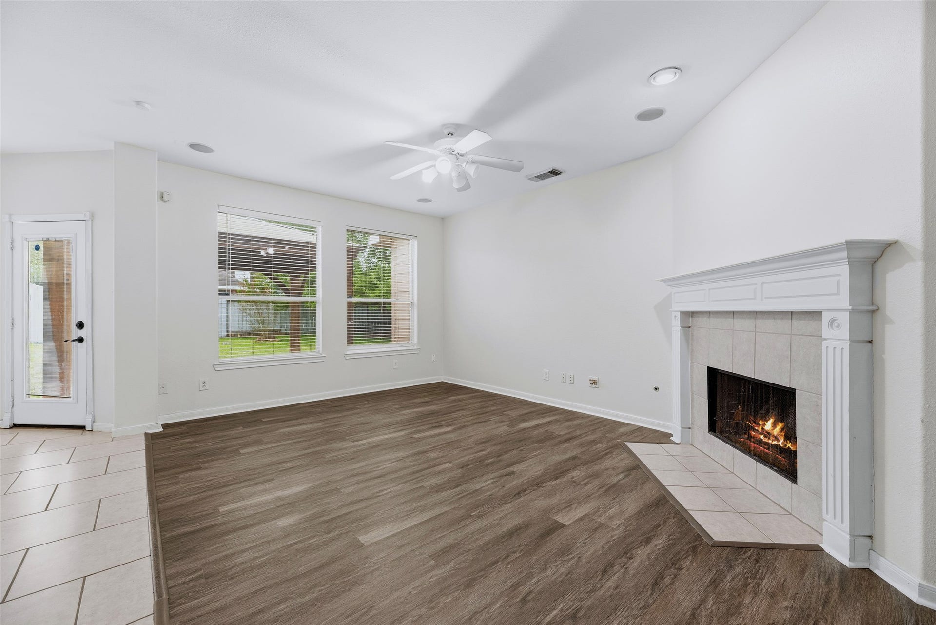 The fireplace anchors the family room, while rear windows and the nearby backyard door connect the indoor living space with the outdoors.