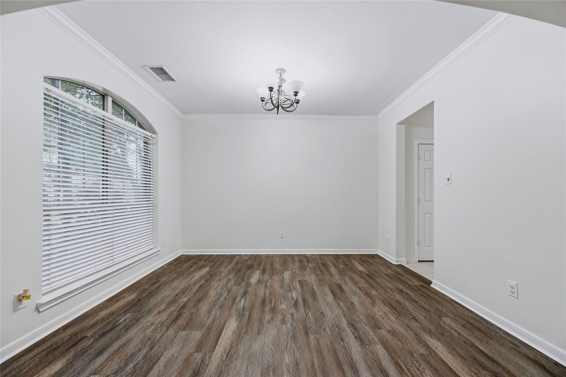 A large arched window and chandelier define the separate dining room, giving you a dedicated place for meals or flexibility for your own setup.