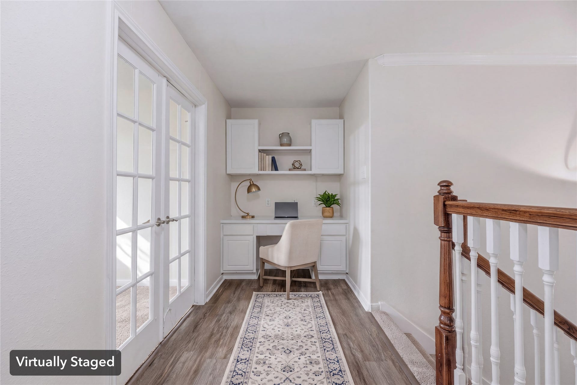 Virtually staged to illustrate the upstairs desk nook beside the French-door room. Furniture, decor and center shelf shown are digital.
