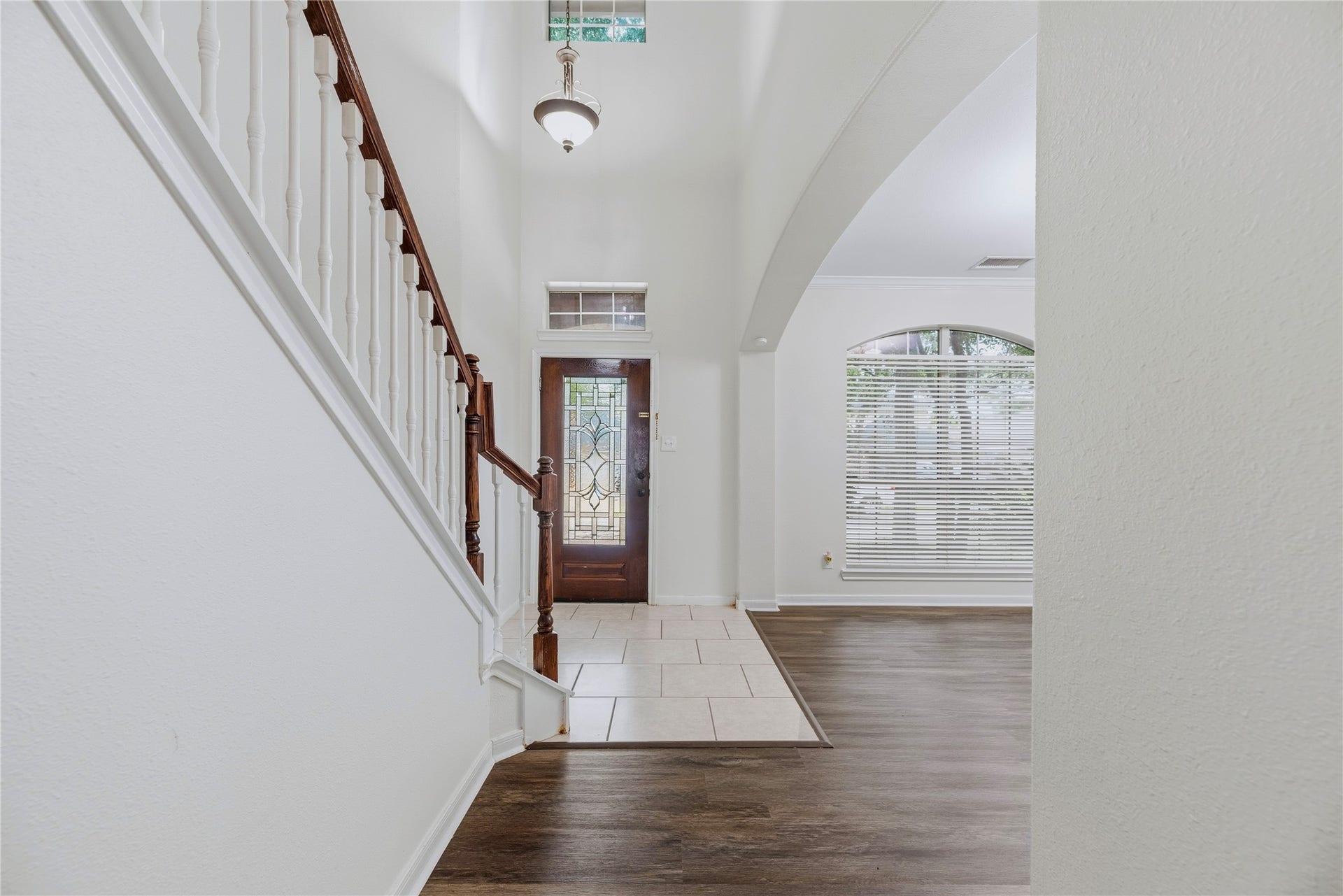 The two-story foyer brings an open feel to the entry, while the front window and decorative-glass door draw daylight into the adjoining spaces.