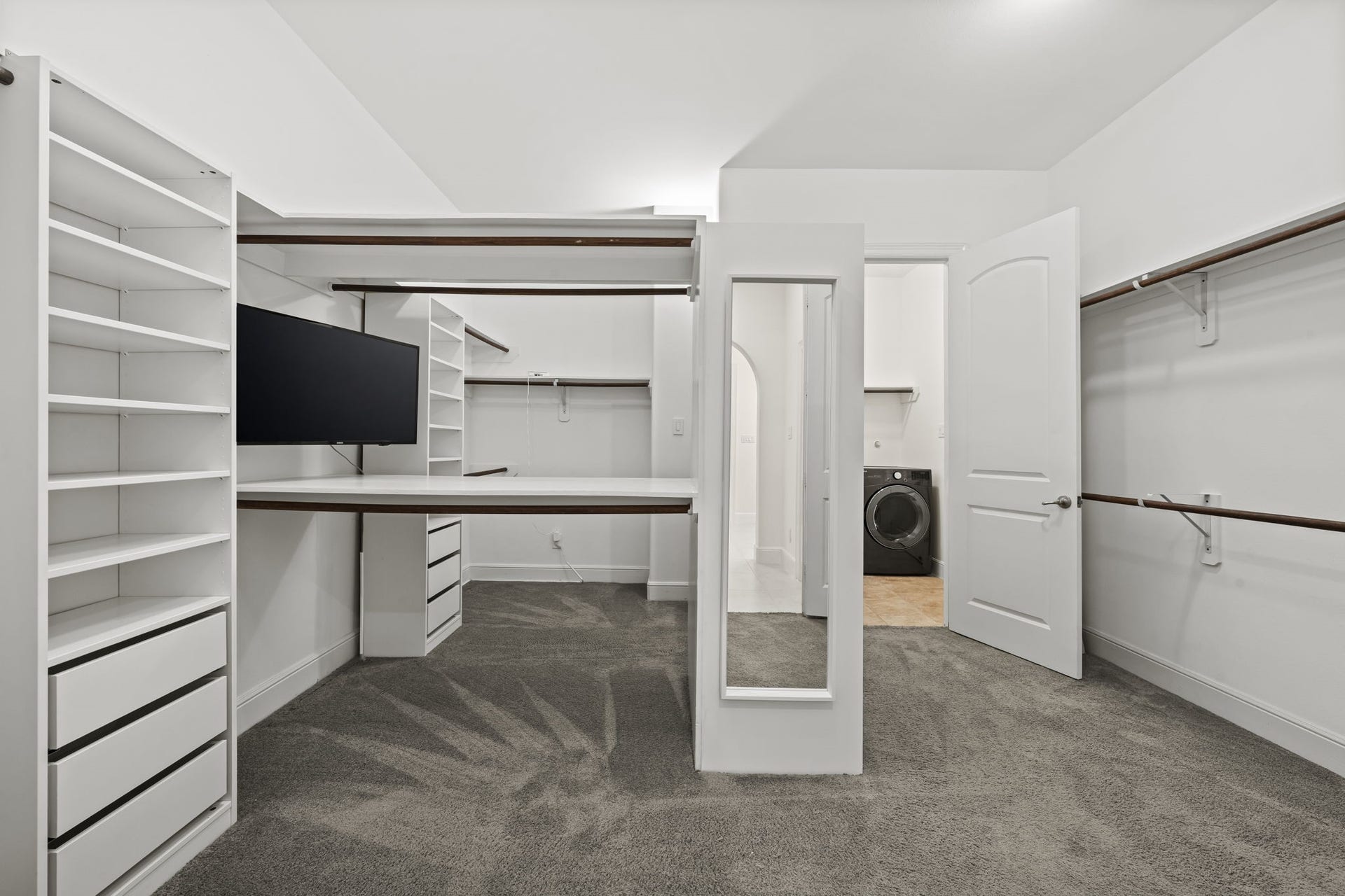 The expansive primary closet offers extensive built-in shelving and hanging space. Its thoughtful configuration keeps wardrobes and accessories beautifully organized.