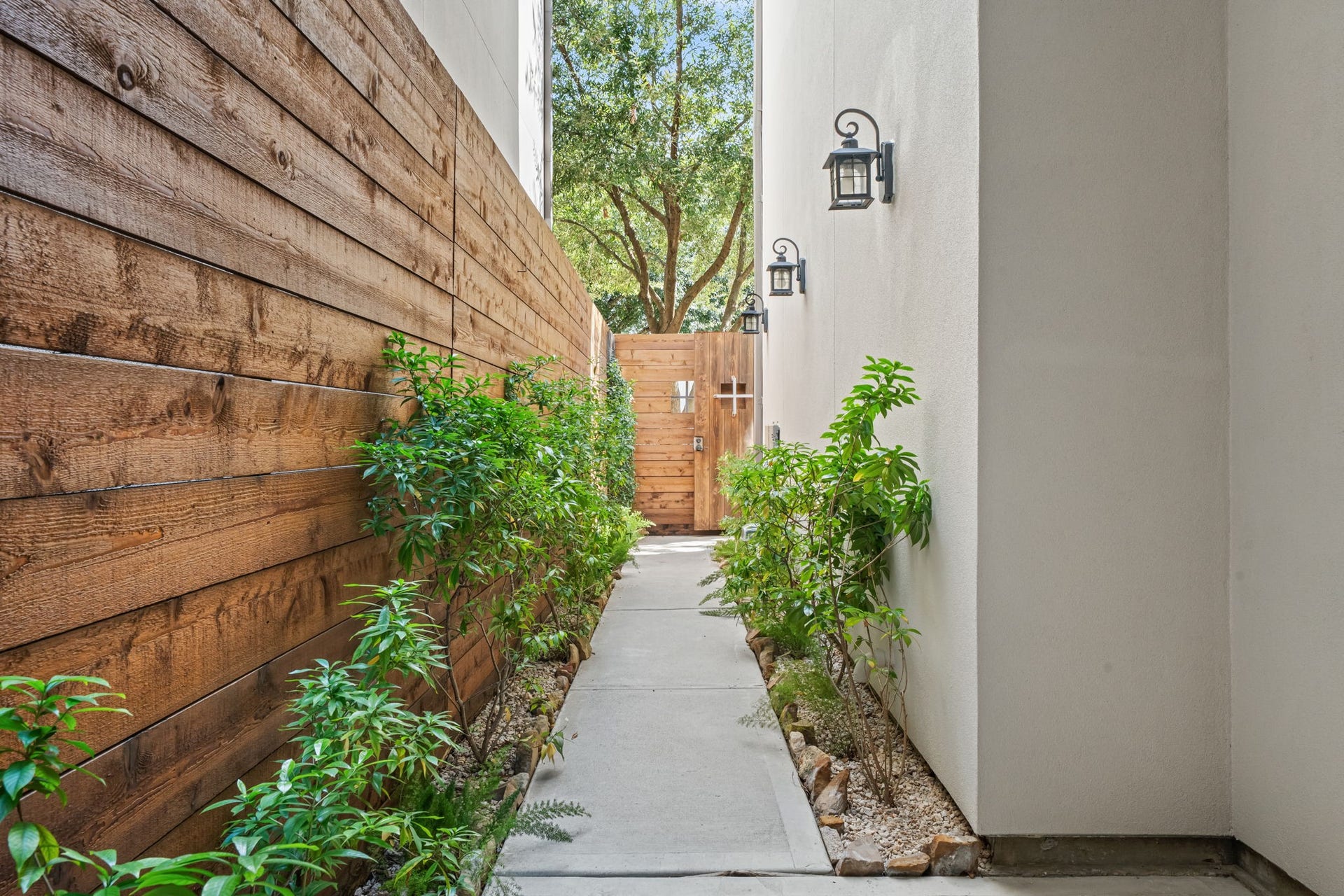The intimate courtyard introduces a quiet outdoor retreat framed by warm wood fencing and established plantings. Its thoughtful placement provides a graceful connection between the entry and interior.