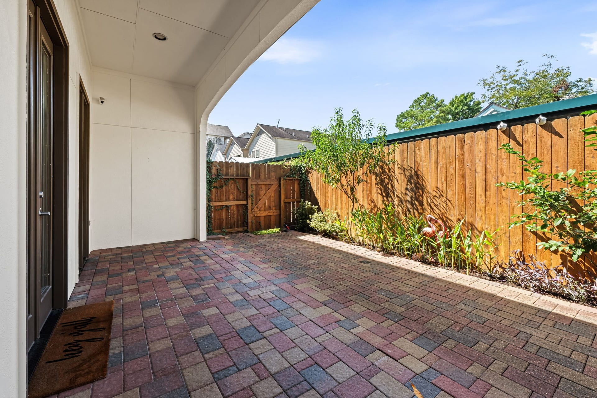 The private courtyard offers a peaceful outdoor extension of the home with brick paving and wood fencing. Established landscaping adds greenery while preserving a low-maintenance setting.