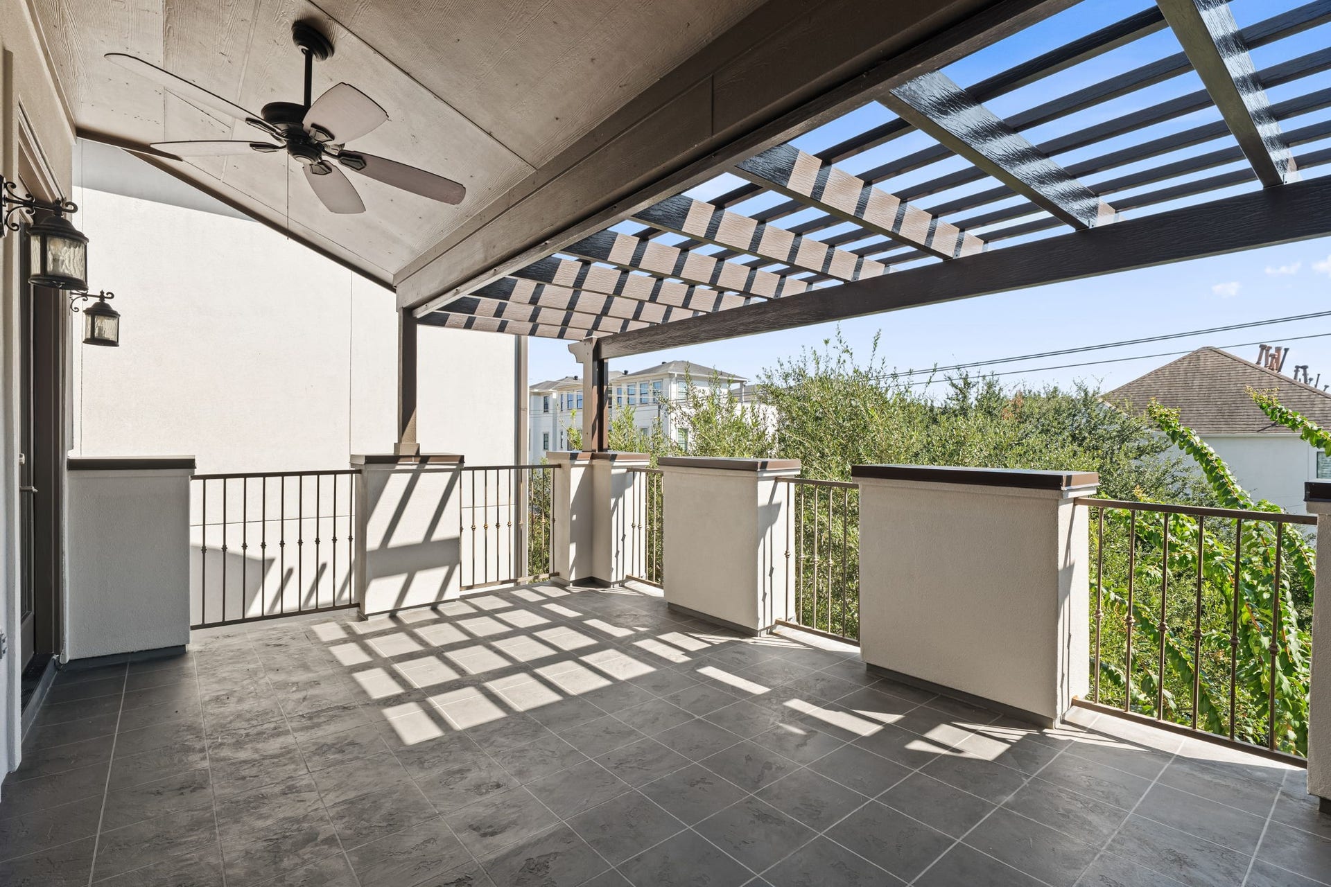 A broad covered rooftop offers shade, privacy, and room to enjoy Houston's changing seasons. Open neighborhood views enhance this inviting upper-level escape.