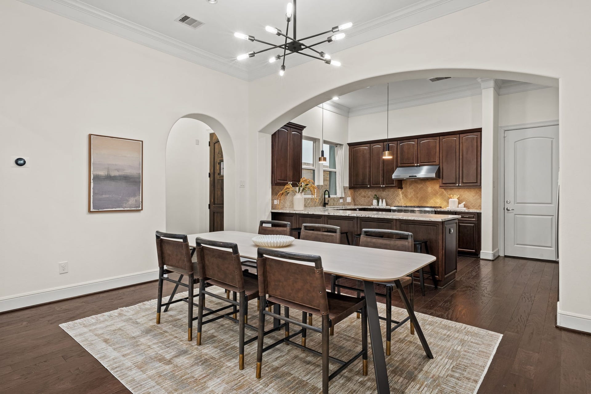A seamless connection to the kitchen makes the dining area equally suited to relaxed meals and polished entertaining. Warm wood floors carry visual continuity throughout the main level.