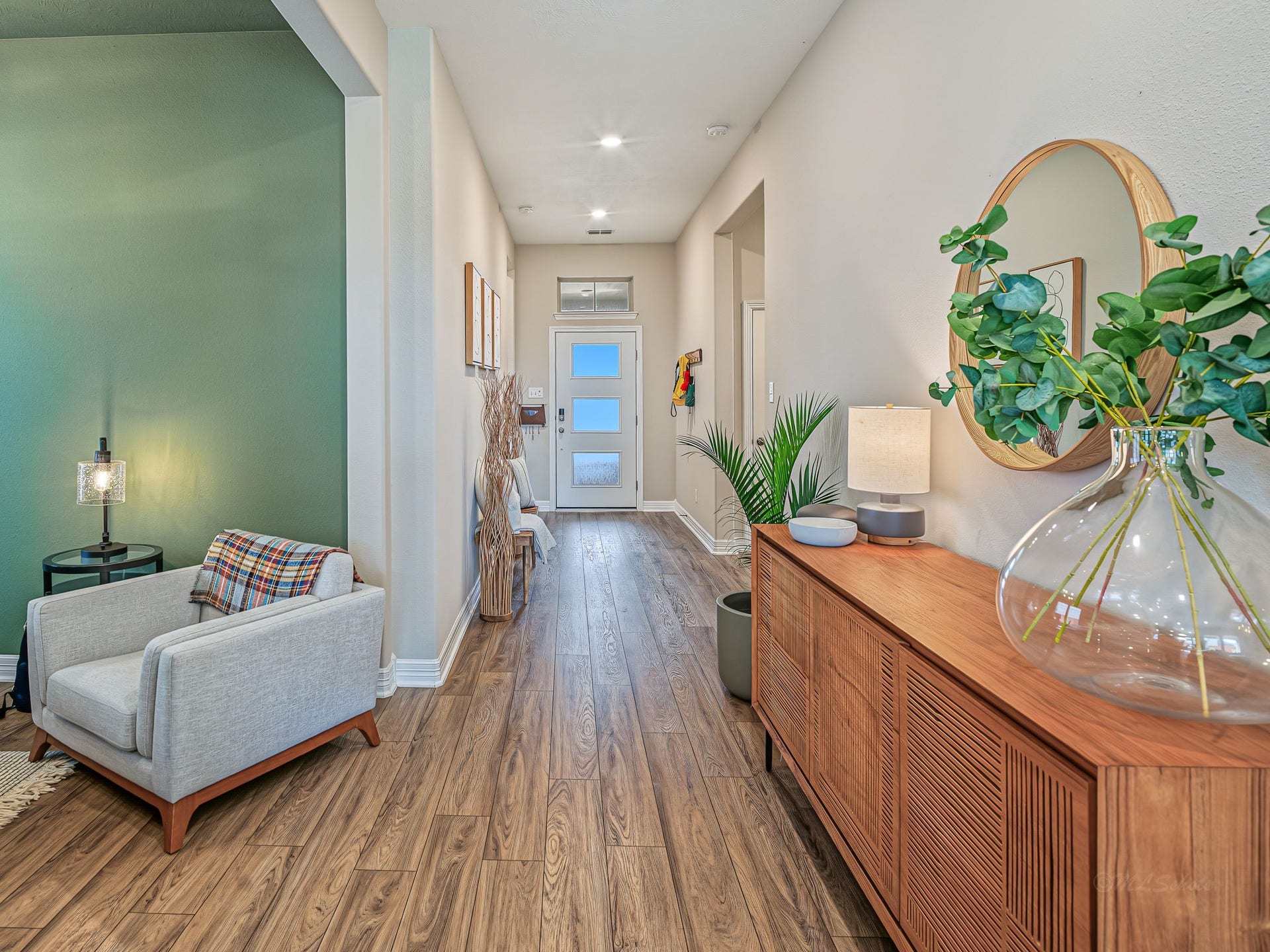 This is such a popular floor plan! The gallery corridor looking back towards front door offers so much expansive wall space. Notice the gorgeous texture of the floors! And here's an owners secret for you - the reeded glass front door gives the most beautiful sunset light show in the gallery hall.