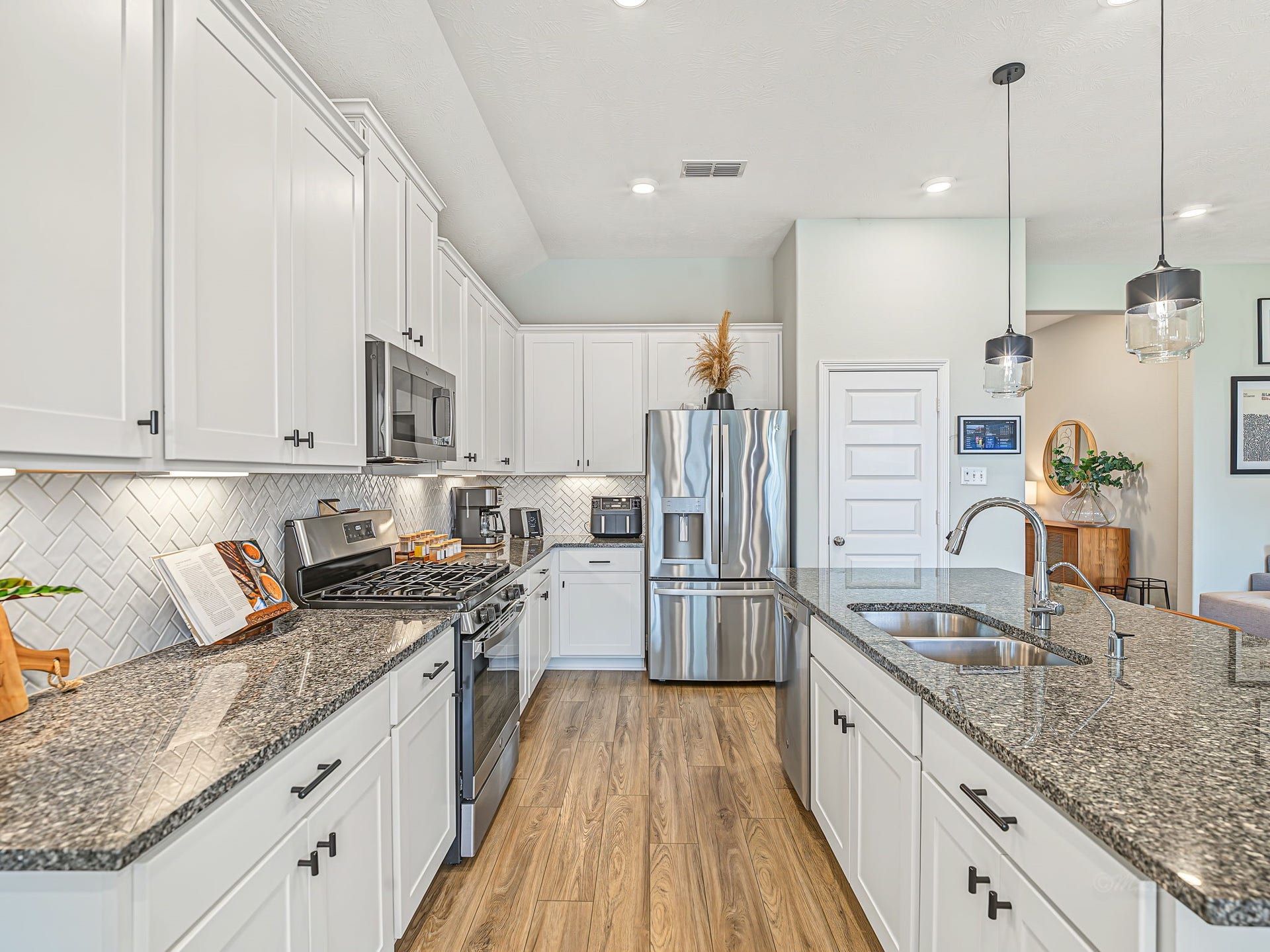 The kitchen elements are so pretty! Classic white cabs with black hardware and coordinating granite. Chef's kiss!!