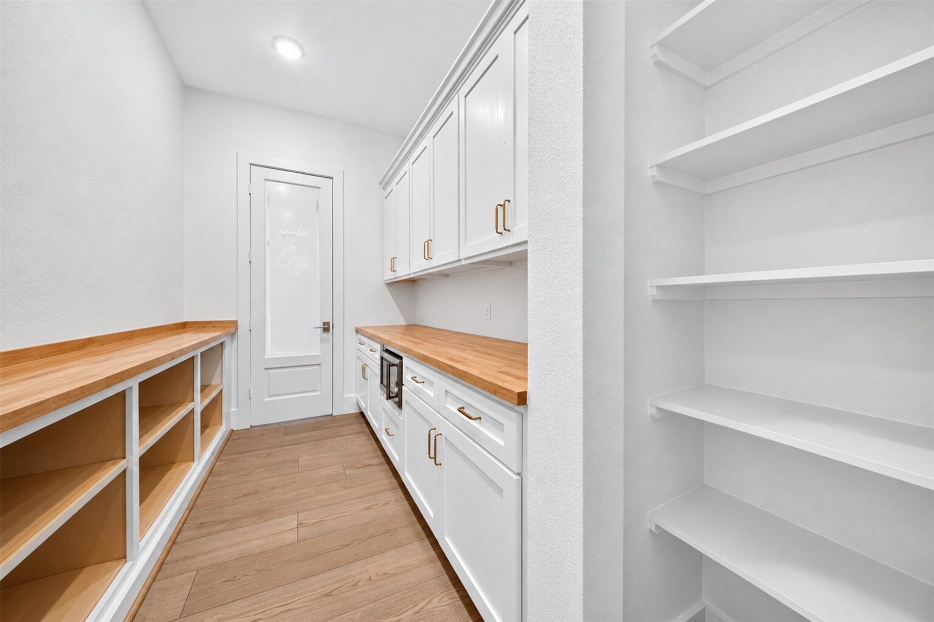 35851 Pineridge Road, Waller, TX 77484 The walk-in pantry pairs wraparound shelving with white cabinetry, butcher-block counters for prep and storage.
