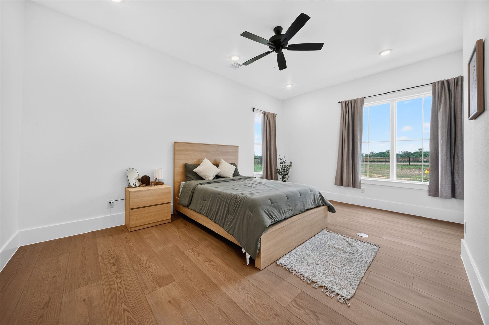 35851 Pineridge Road, Waller, TX 77484 This secondary bedroom looks out over the property through wide windows, with wood-look floors and a ceiling fan completing the space.