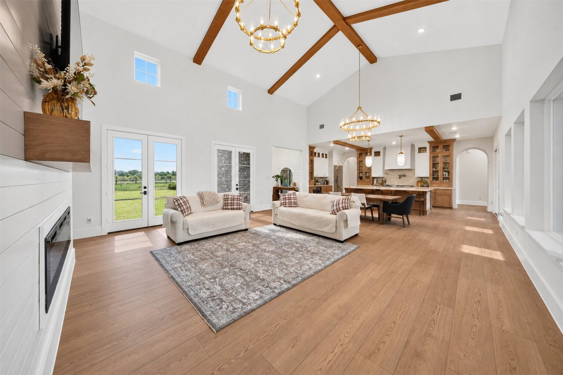 35851 Pineridge Road, Waller, TX 77484 The family room flows into the kitchen beneath exposed beams, while tall windows carry the open sightline out toward the yard.
