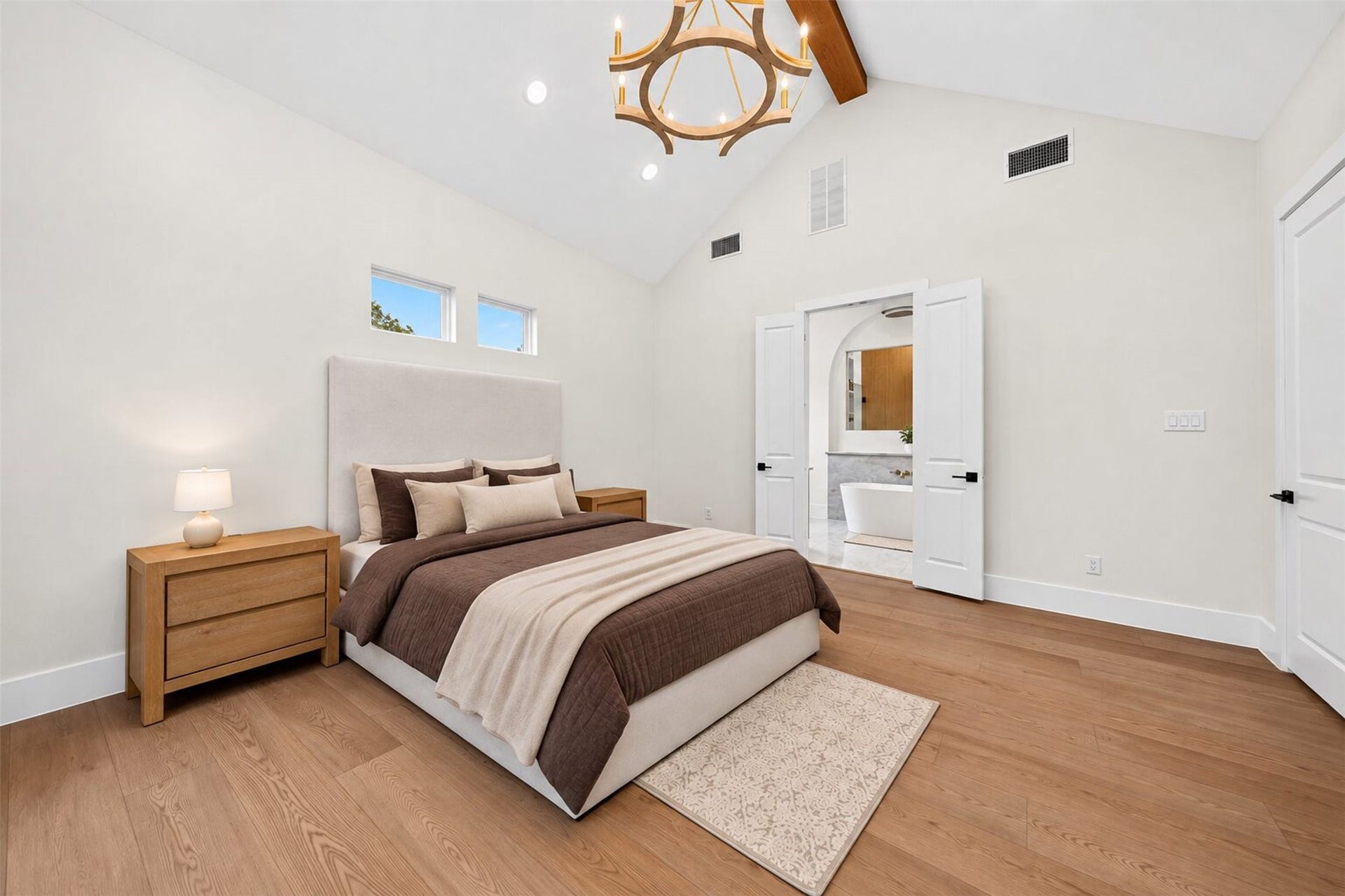 35851 Pineridge Road, Waller, TX 77484 A vaulted ceiling and exposed wood beam give the primary bedroom an airy scale, with a doorway leading directly to the bath.