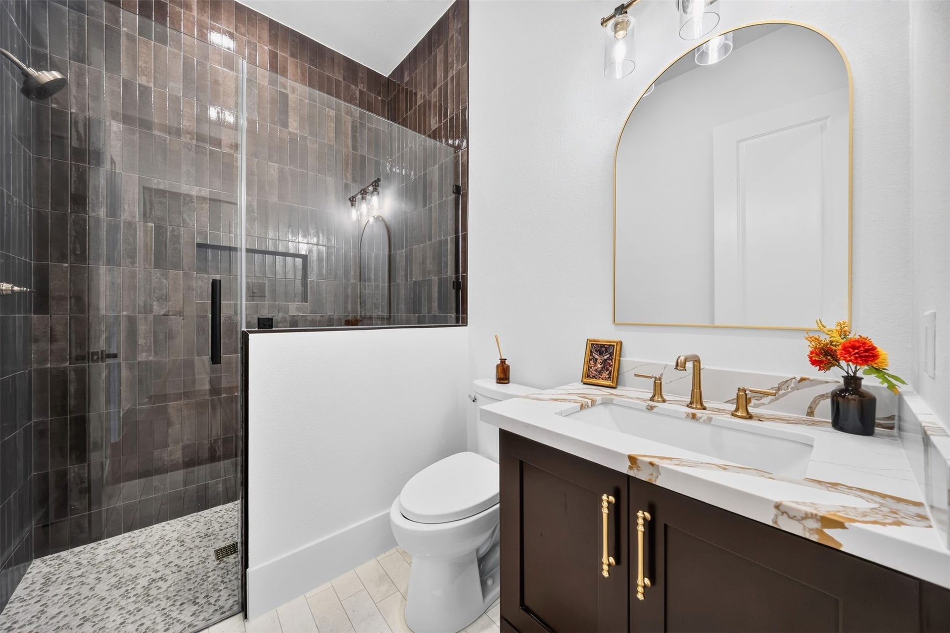 35851 Pineridge Road, Waller, TX 77484 A glass-enclosed shower lined in dark tile contrasts with the light counter and double vanity for a crisp, balanced finish.