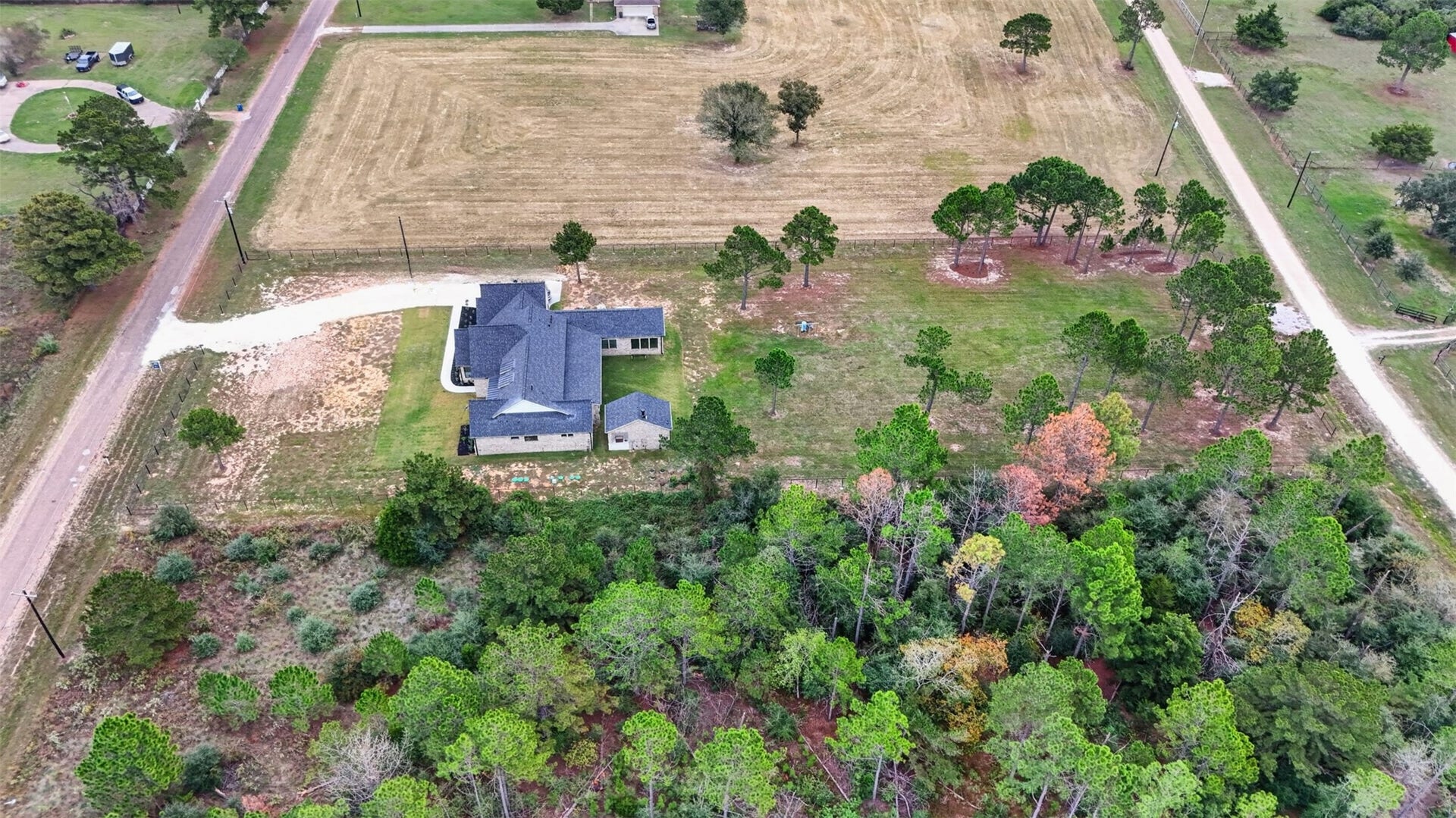 35851 Pineridge Road, Waller, TX 77484 The overhead view reveals the home's layered rooflines, with open acreage and surrounding trees extending beyond the house.