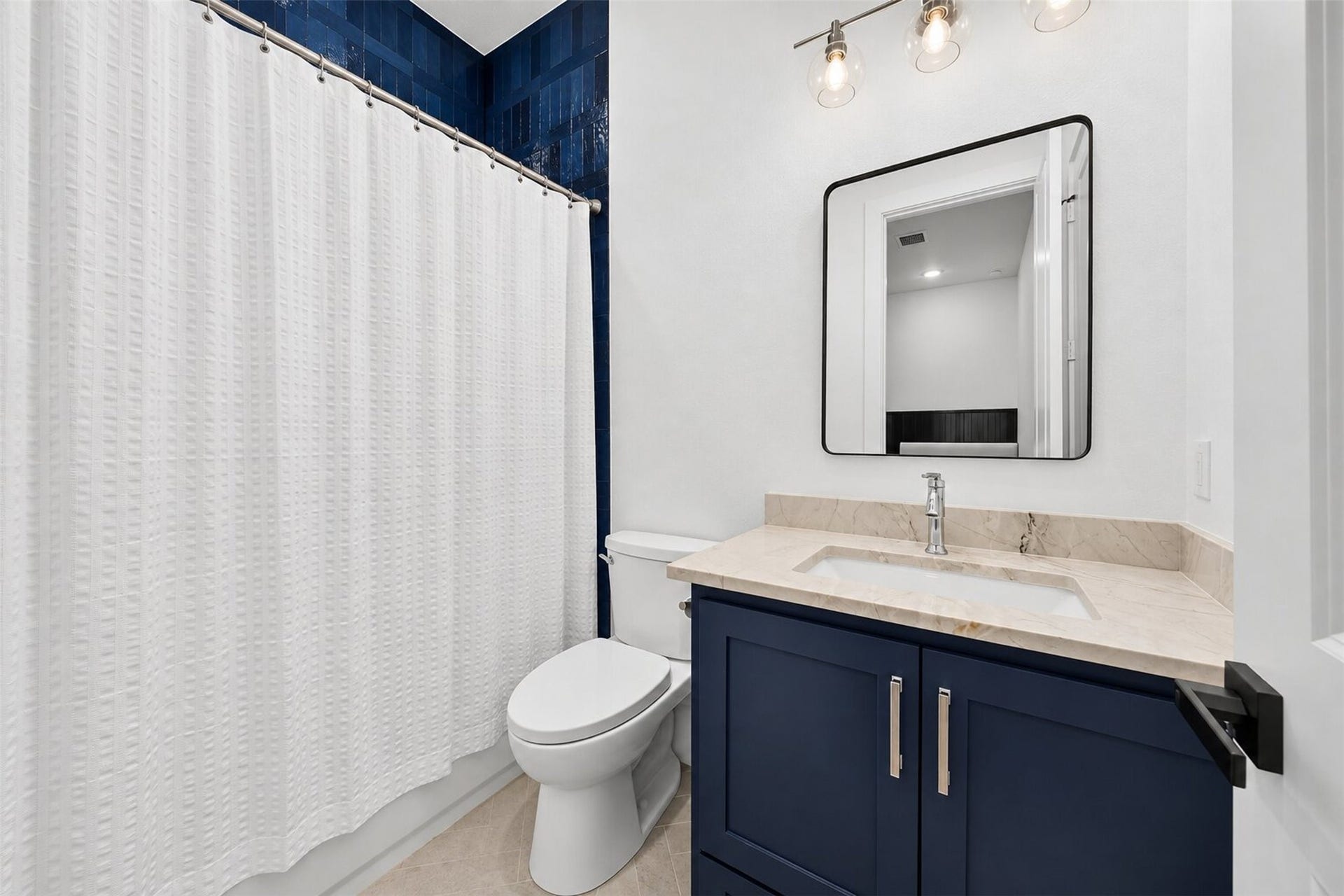 35851 Pineridge Road, Waller, TX 77484 A navy vanity and blue tile accent bring color to this bath, balanced by pale counters and light flooring.