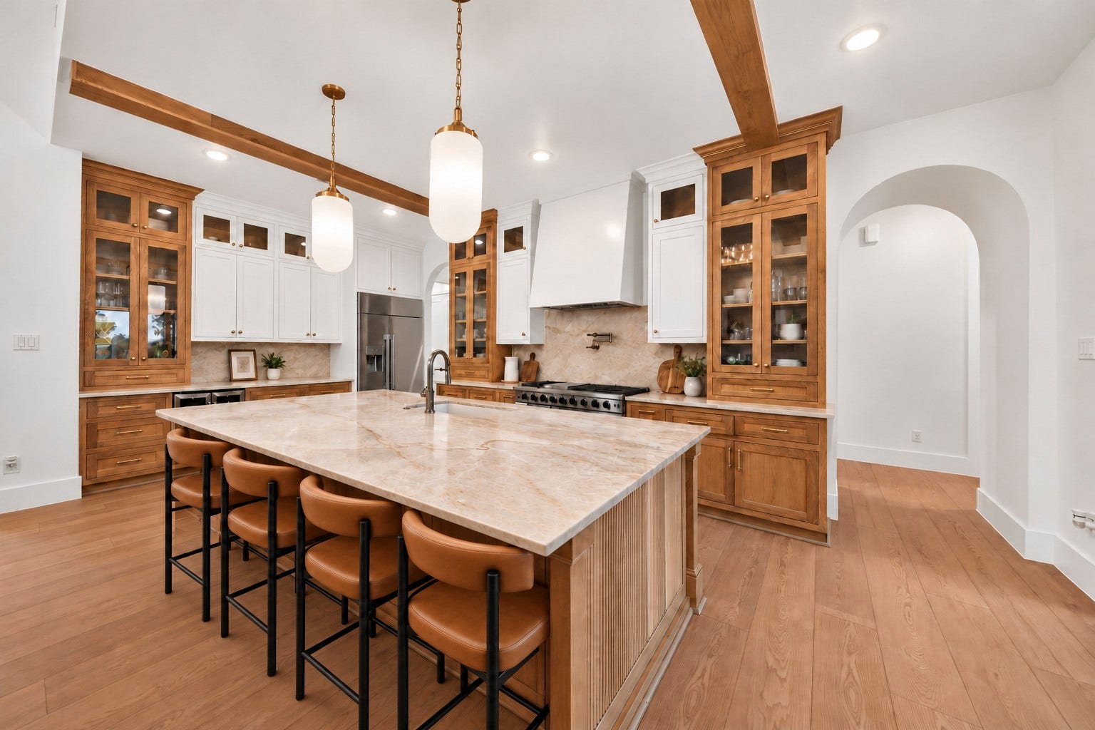 35851 Pineridge Road, Waller, TX 77484 Glass-front wood cabinets surround a broad stone island, while the range and patterned backsplash anchor the kitchen's cooking area.
