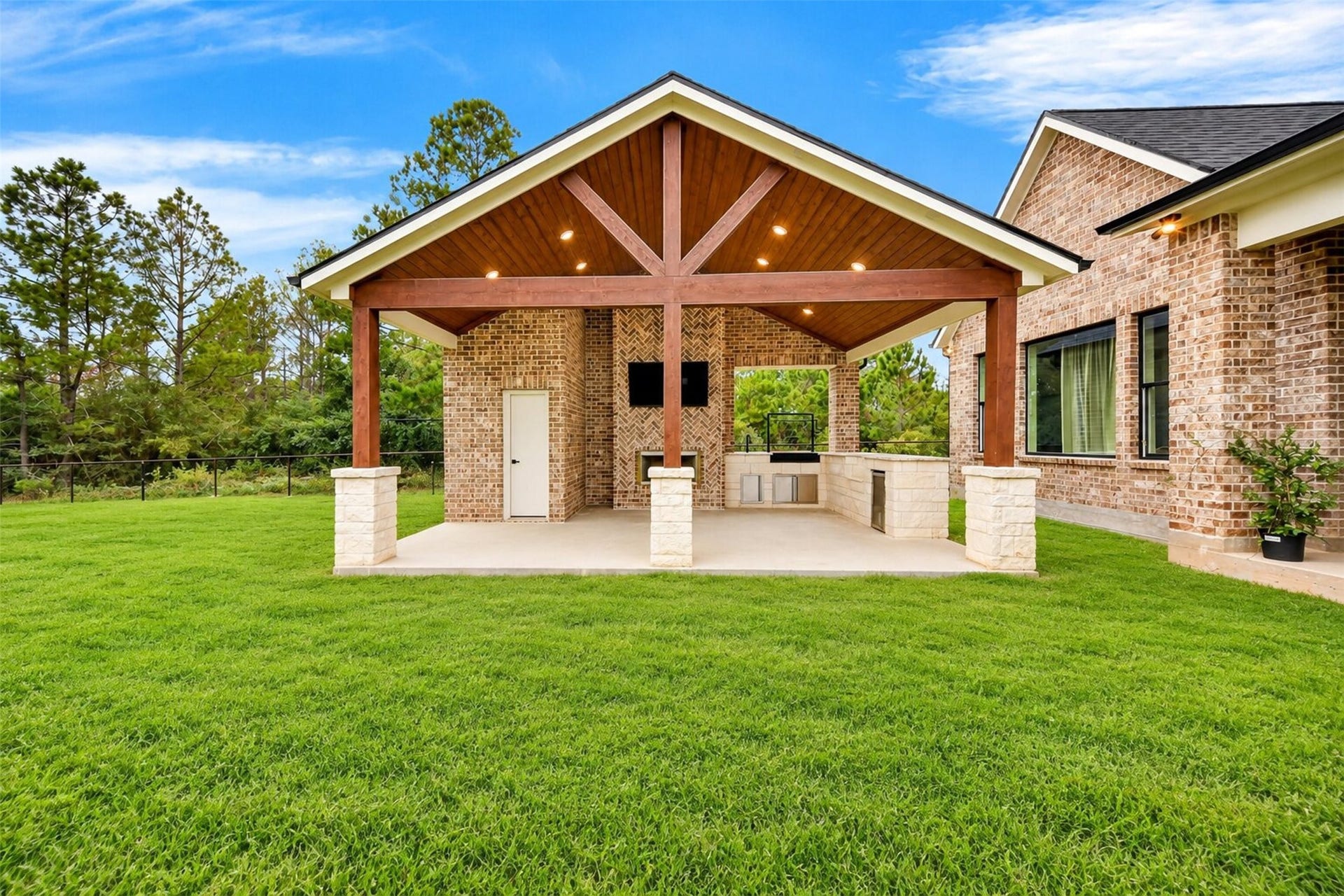 35851 Pineridge Road, Waller, TX 77484 A timber-framed gabled pavilion shelters the outdoor fireplace and kitchen beside the broad backyard lawn.