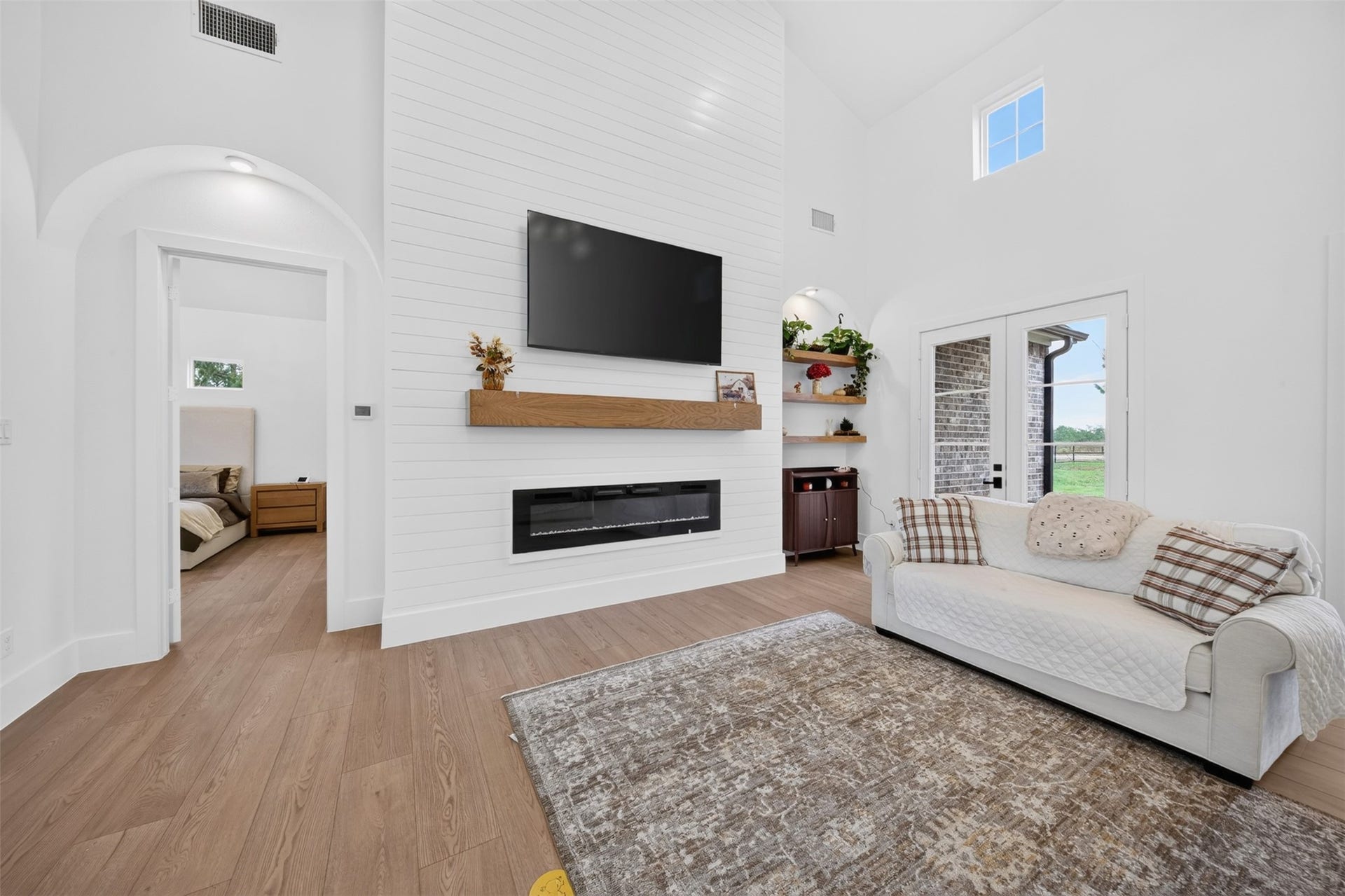 35851 Pineridge Road, Waller, TX 77484 A shiplap fireplace wall, substantial wood mantel, and arched niches add architectural detail to the living room.