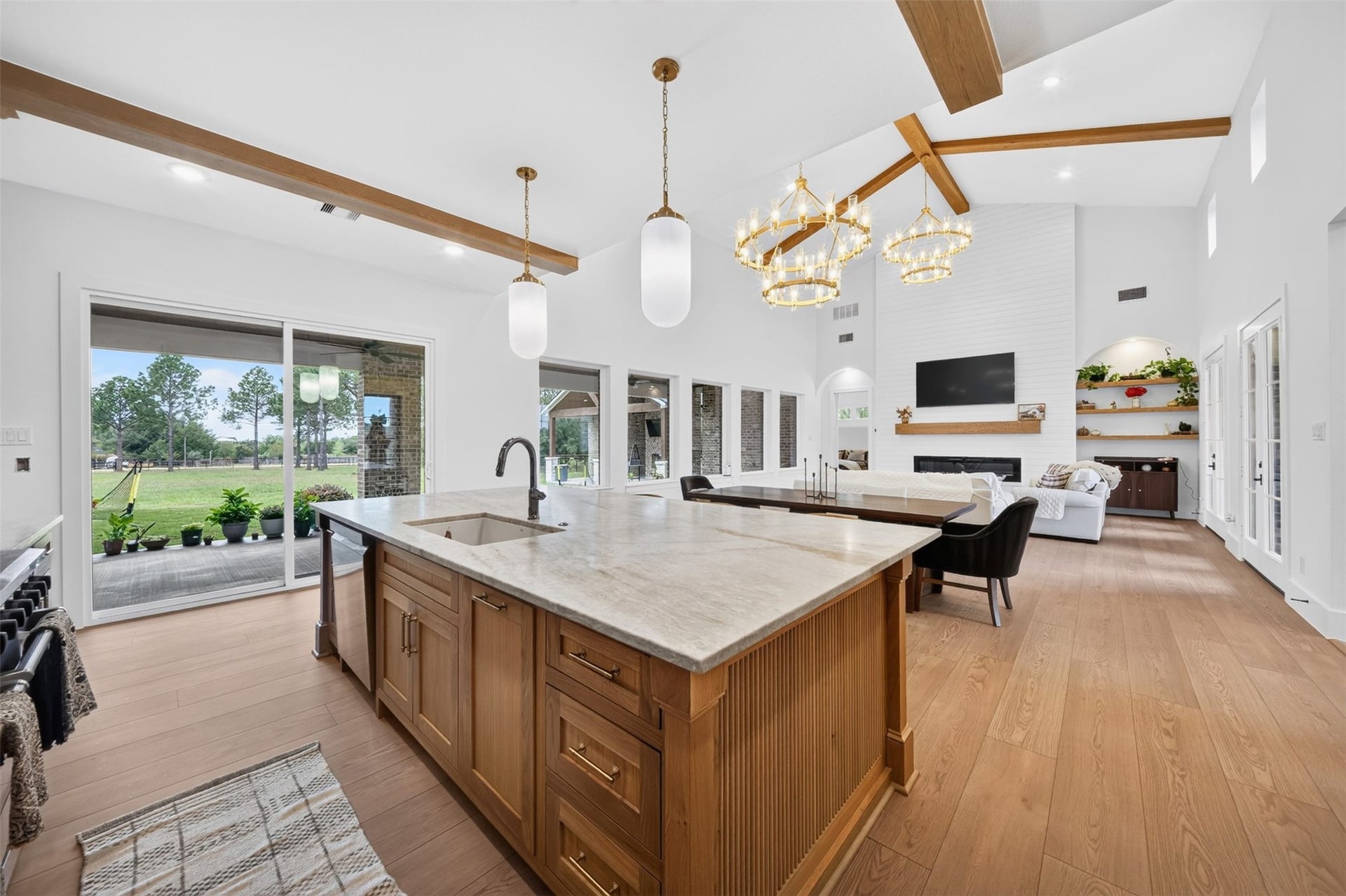 35851 Pineridge Road, Waller, TX 77484 A generous stone island with a fluted wood base and apron-front sink overlooks the family room and connects the kitchen to the living space.