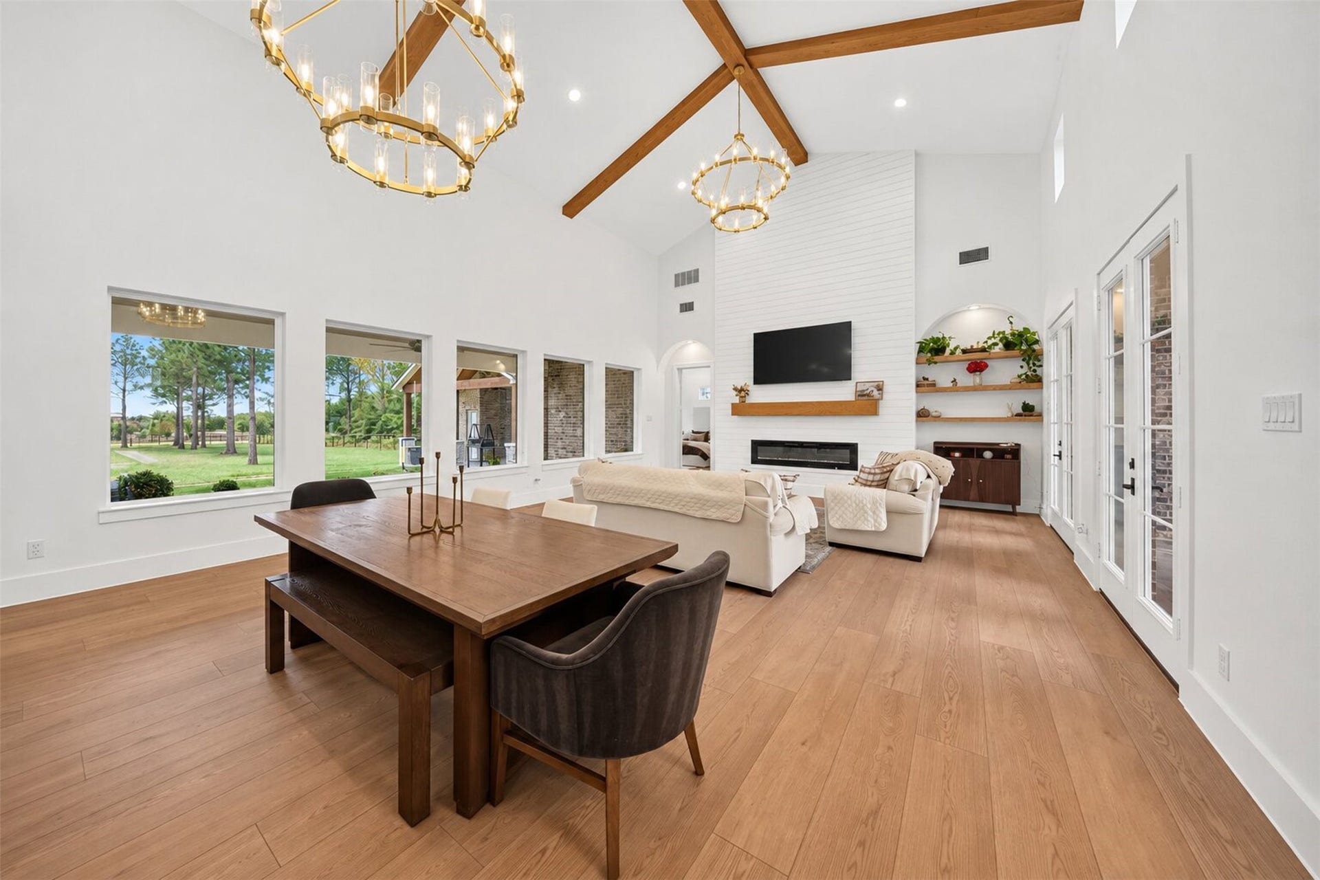 35851 Pineridge Road, Waller, TX 77484 Exposed wood beams cross the vaulted great-room ceiling, while tall windows and a shiplap fireplace wall give the space an airy feel.