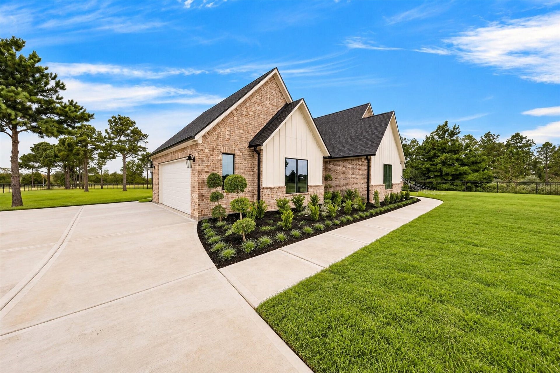 35851 Pineridge Road, Waller, TX 77484 The long concrete drive follows the side elevation, with low planting and mature trees softening the brick exterior.