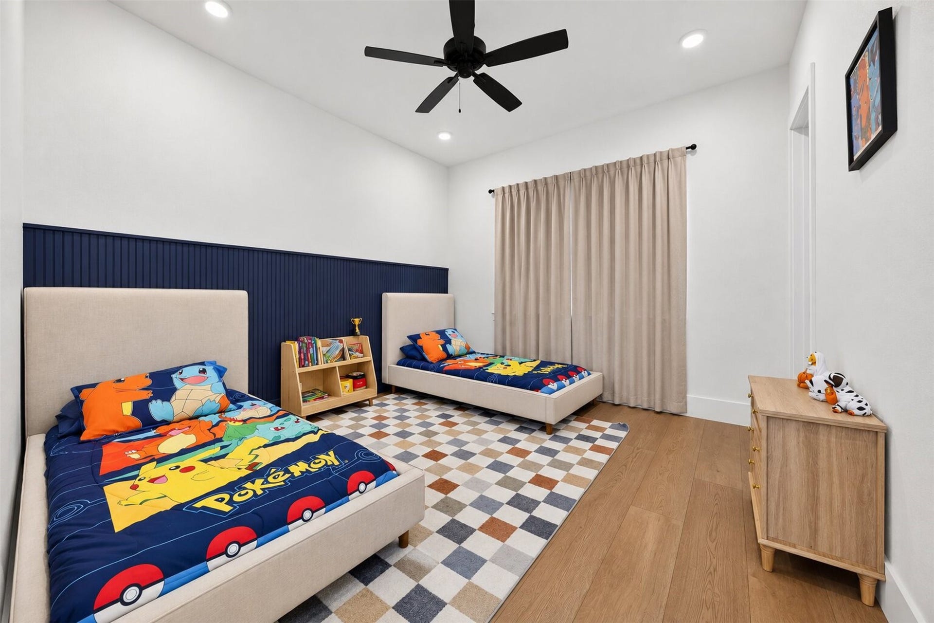 35851 Pineridge Road, Waller, TX 77484 Navy board-and-batten adds a distinctive architectural accent to this bedroom, complemented by a ceiling fan and wide window.